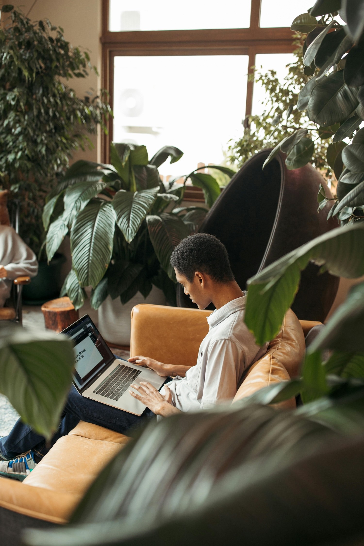 man sitting on the couch and working on a laptop