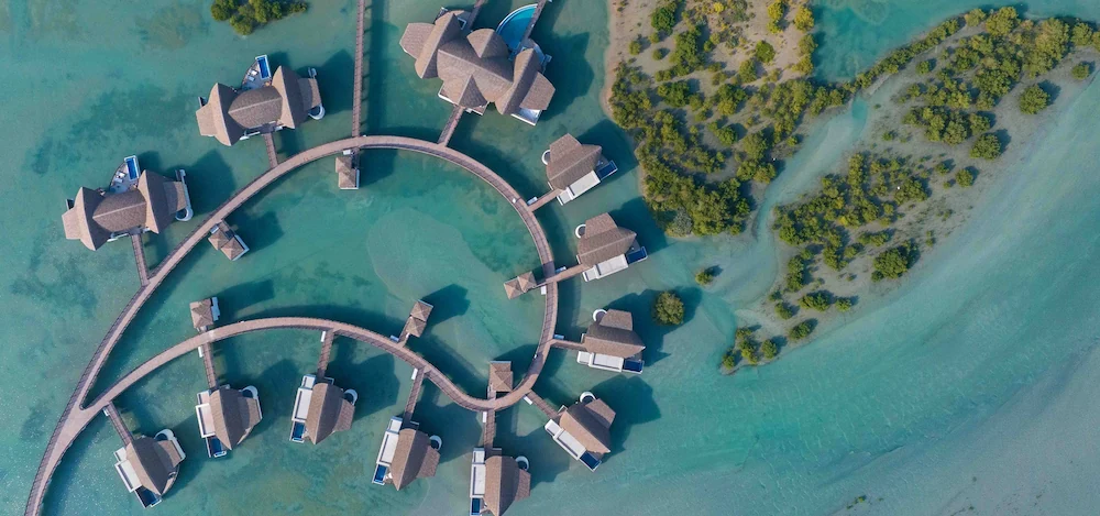 green chairs under umbrellas on shore