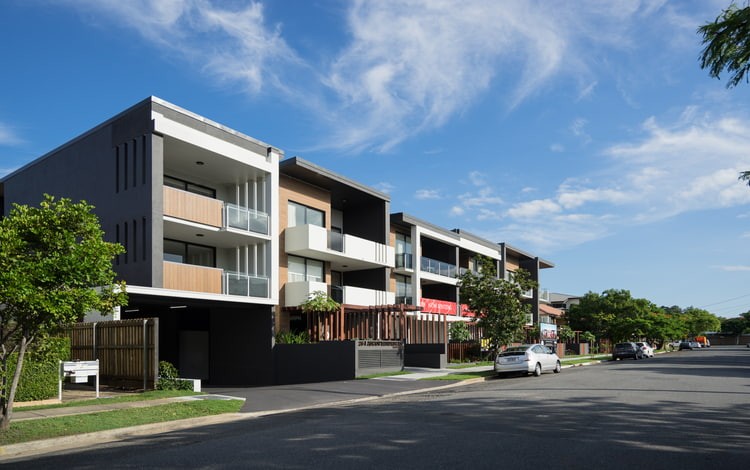 The corner of a street features the new Ascot Residences apartment building, highlighting contemporary architectural style.