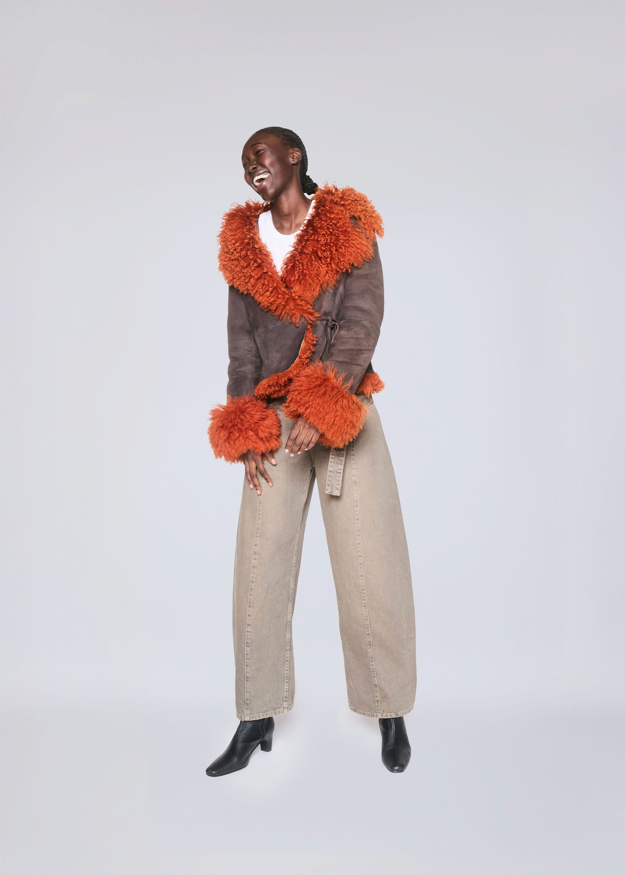 Young woman with dark hair and bangs, wearing red.