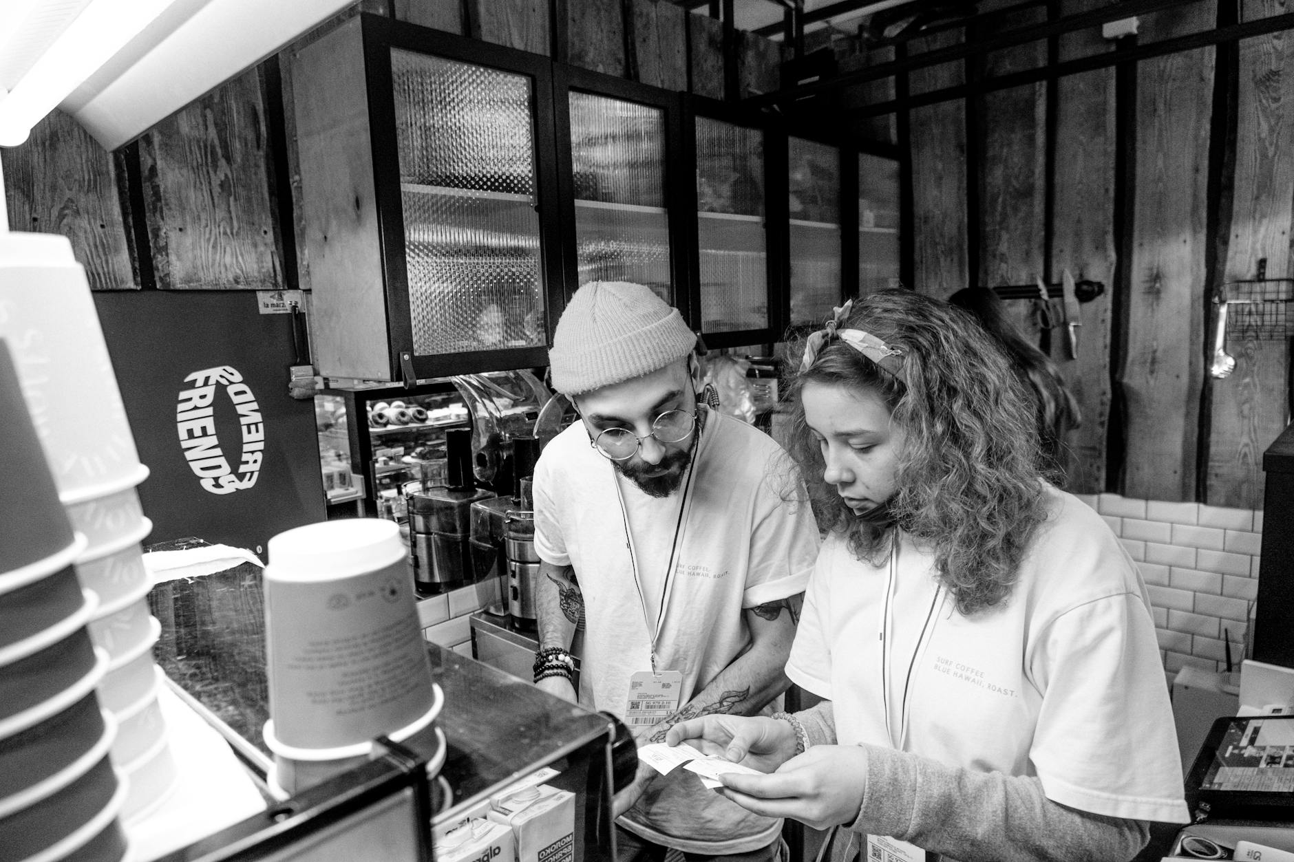Echipă multietnică de baristas într-o cafenea, conversație în pauză