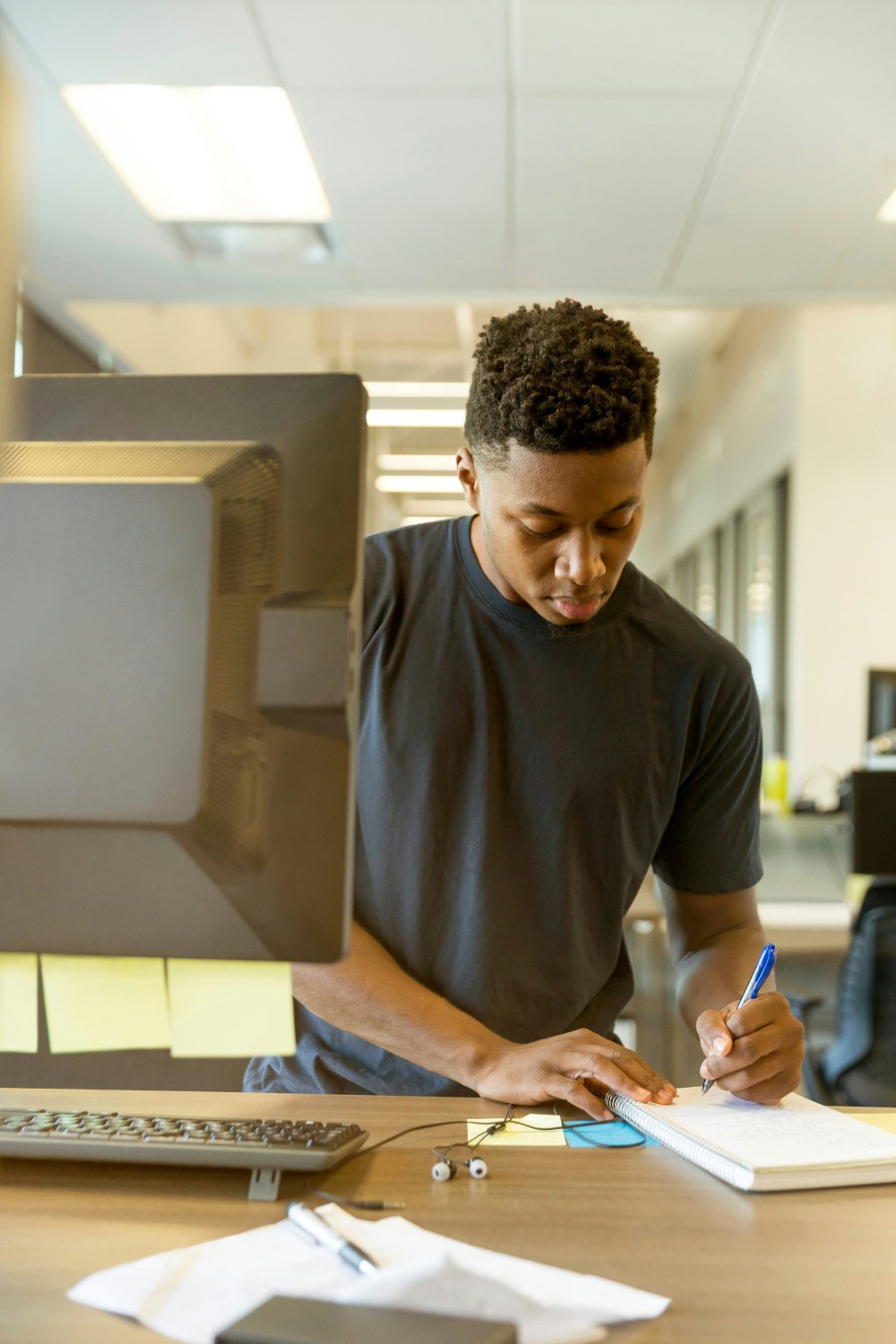 A young man working at a desk, illustrating productivity and motivation in a flexible payroll system.