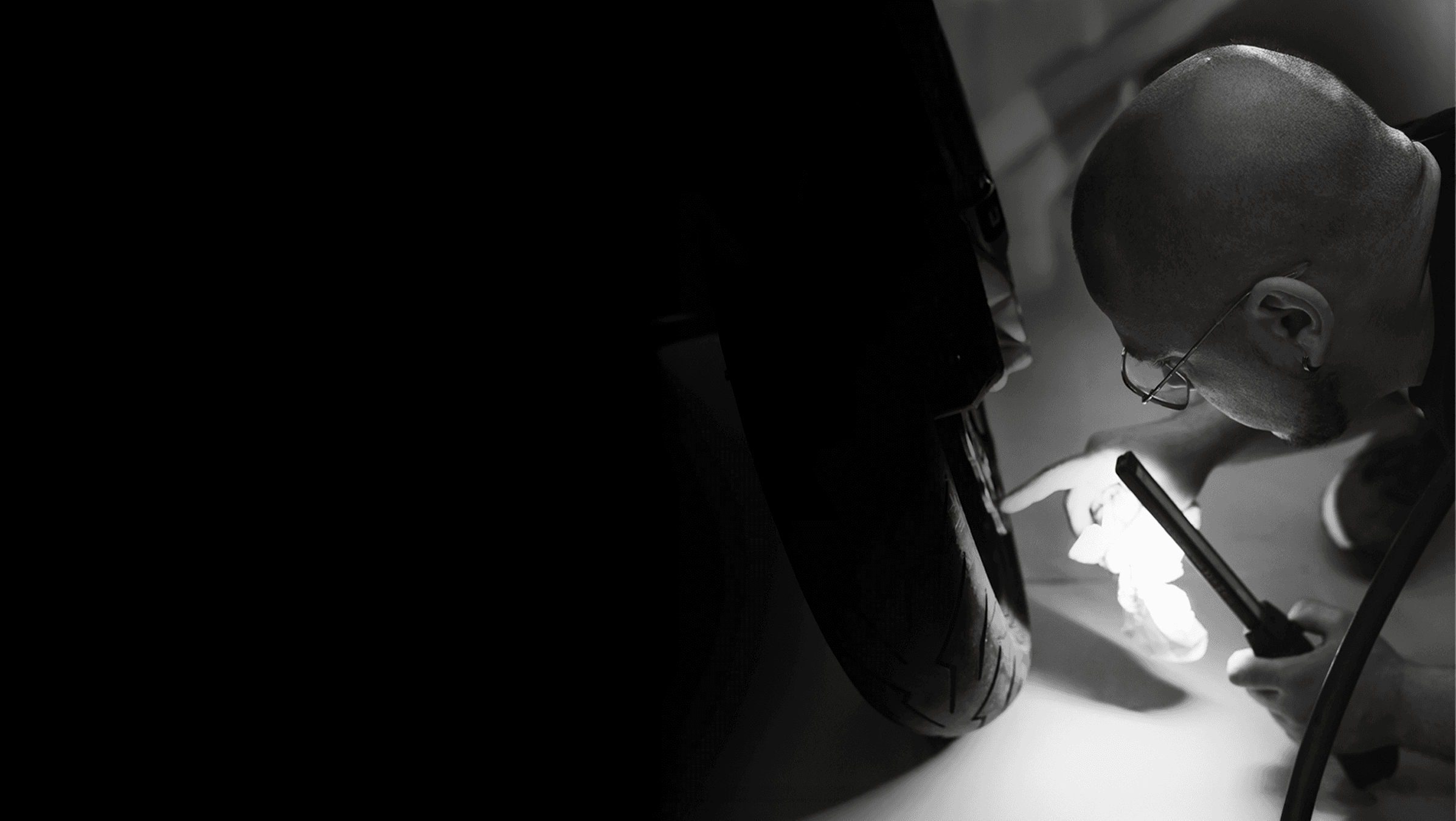 Black and white image of people working at a table with laptops, showing hands gesturing during discussion of digital content displayed on screens, with fabrica® logo in the corner.