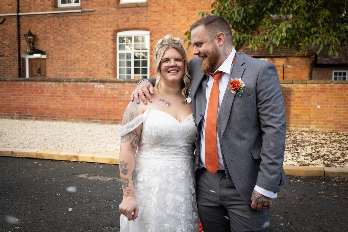 Hannah and Shawn smiling together outside at the Charlecote Pheasant Hotel in Warwickshire