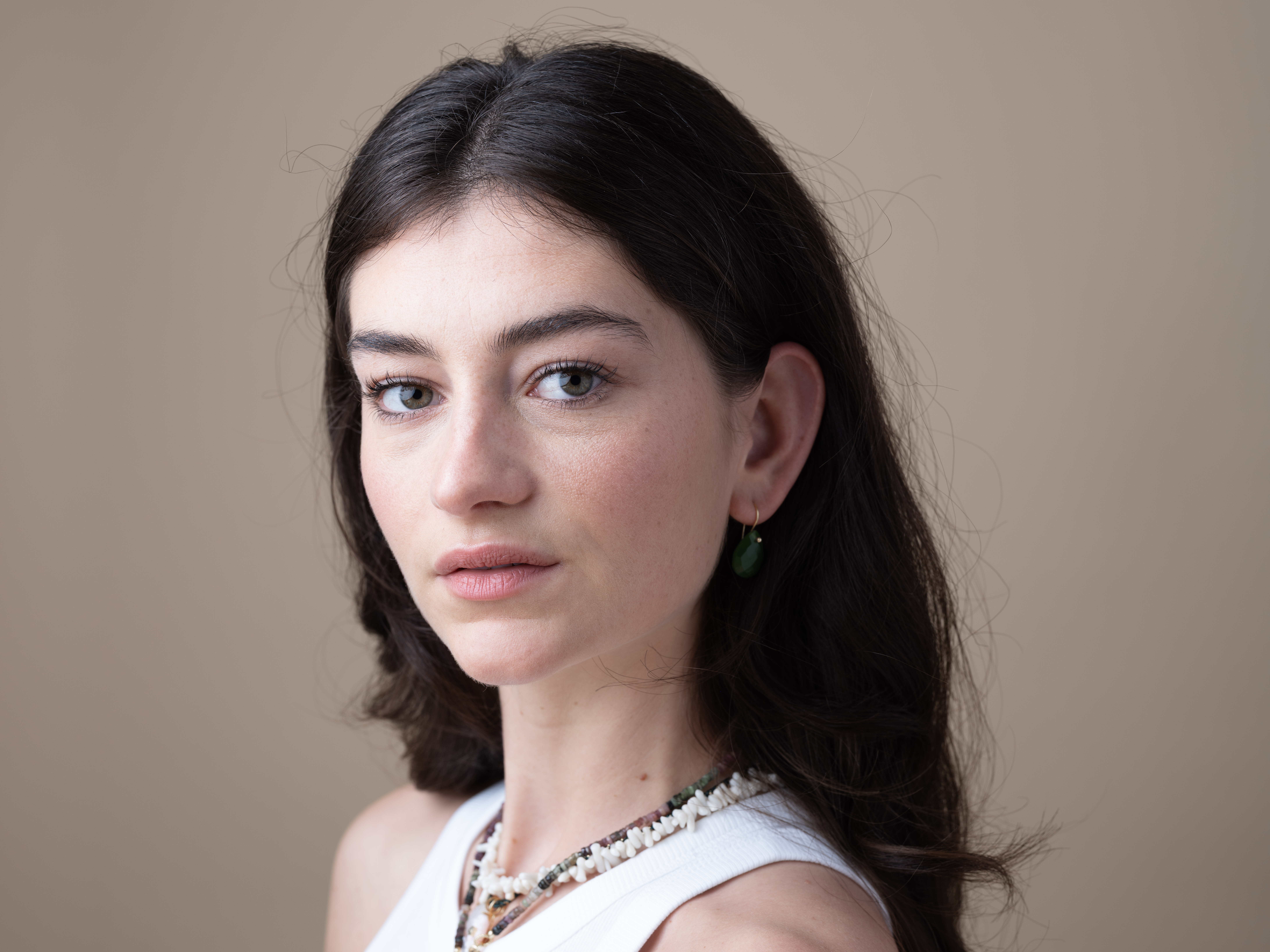 Close-up portrait of Gill in a studio against a light brown backdrop.