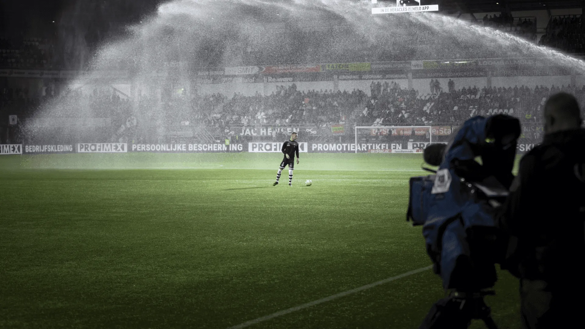 A wide shot of a footbal field with a single player