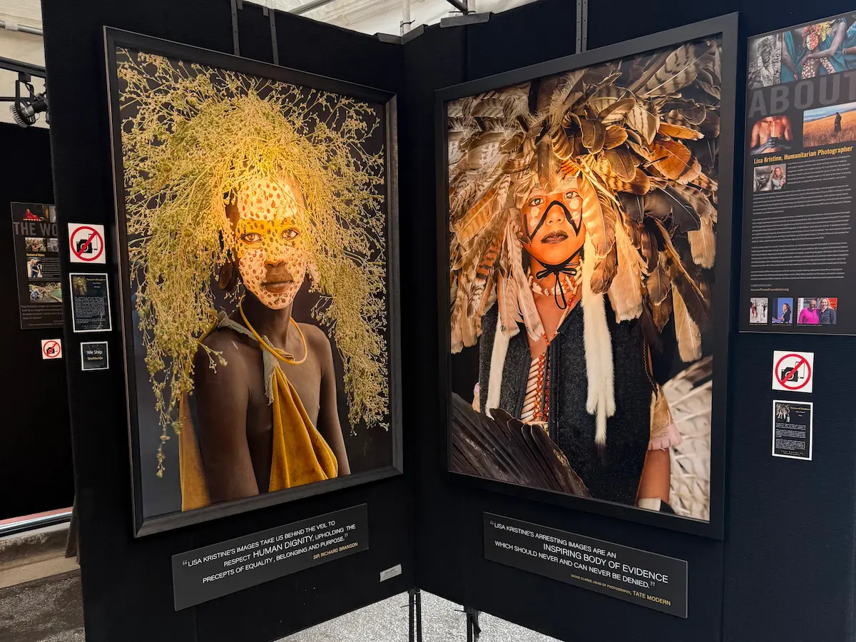 Large portrait photography pieces displayed at Artisphere in downtown Greenville, featuring people in detailed ceremonial dress and natural adornments.