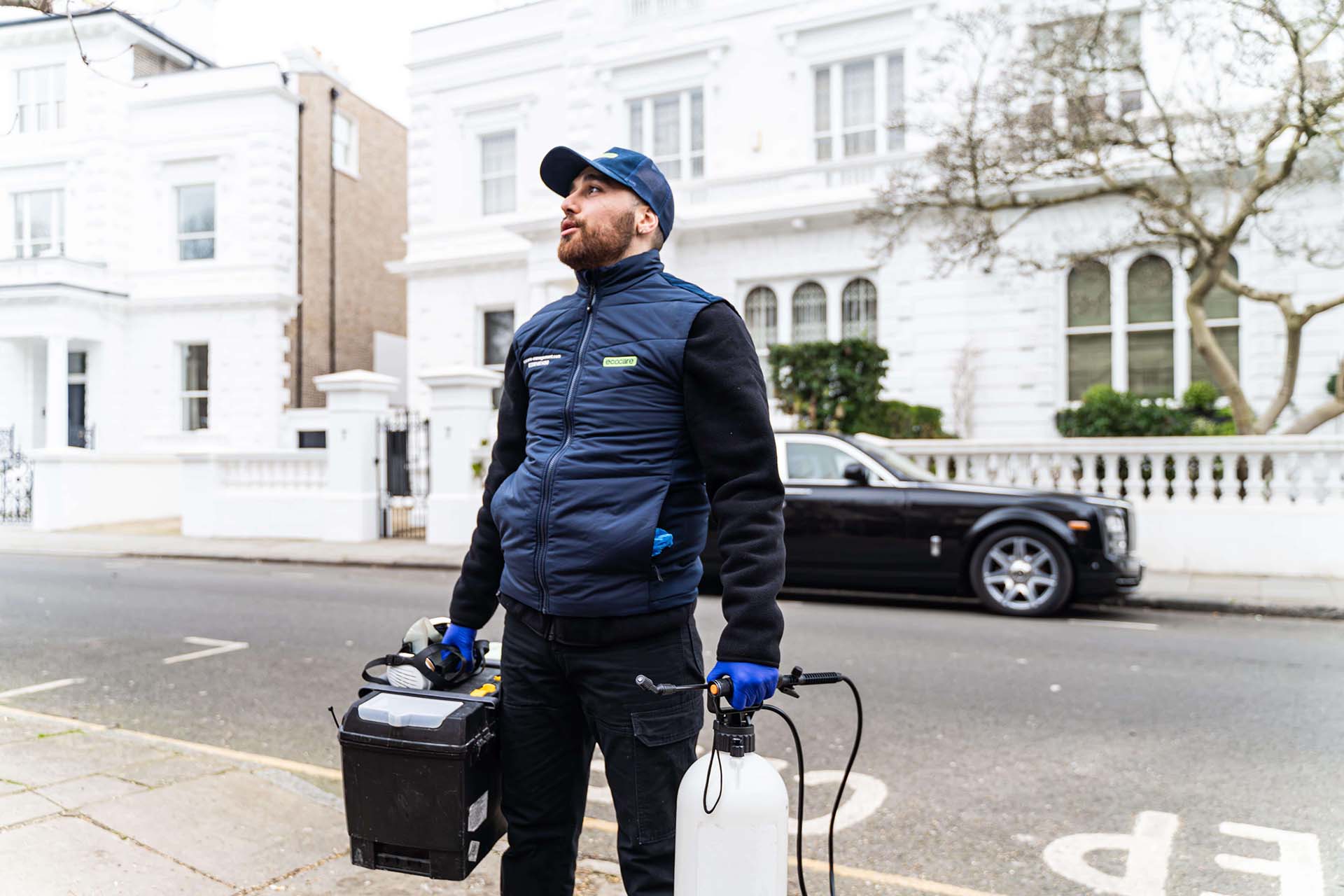 Pest control technician with equipment outside London hotel - Professional bed bug treatment for hospitality industry