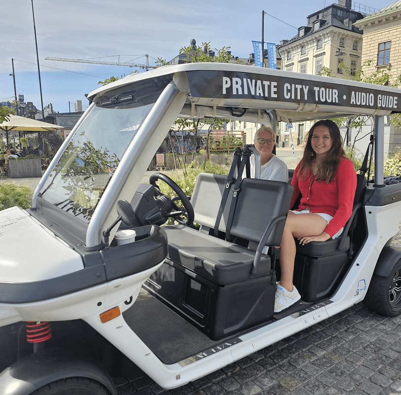 Tourists exploring Stockholm during private electric sightseeing cart tour
