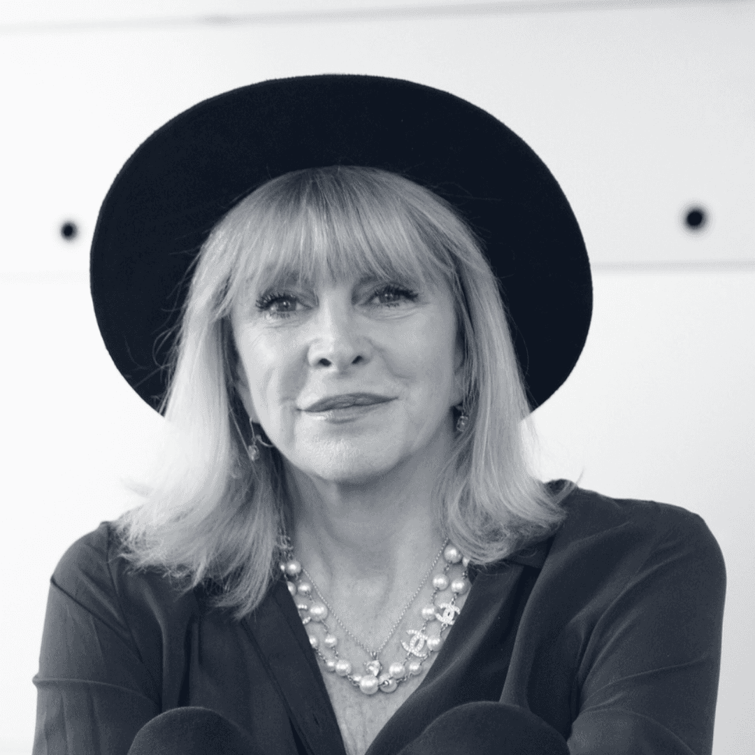 Portrait of a woman with long, smooth hair swept to the side, in a dark t-shirt, on a plain background.