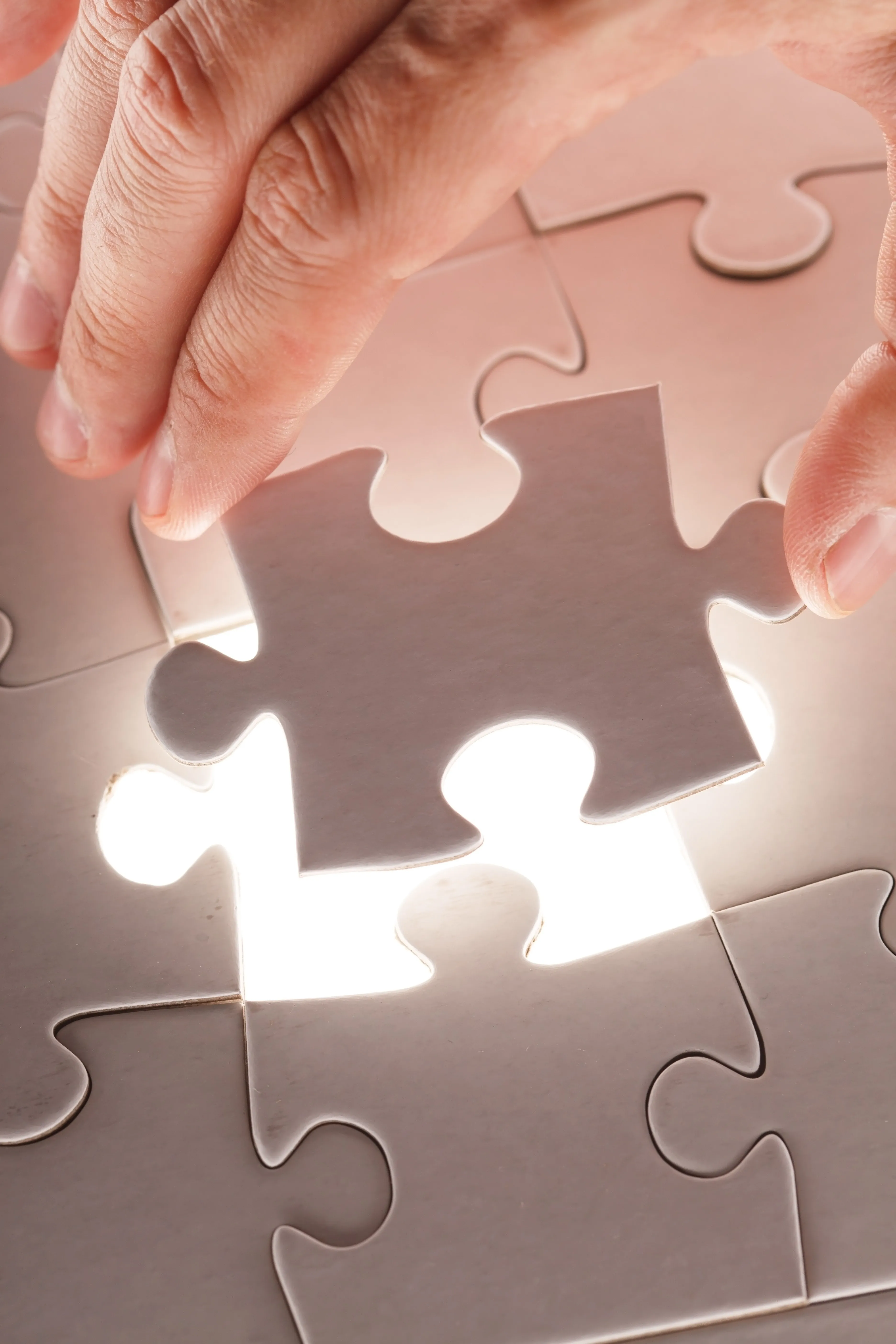 Hands fitting jigsaw together