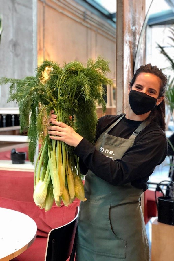 Friendly waiter from As One Restaurant Dublin holding up organically seasoned vegetables to show that it's important to support better and local farming