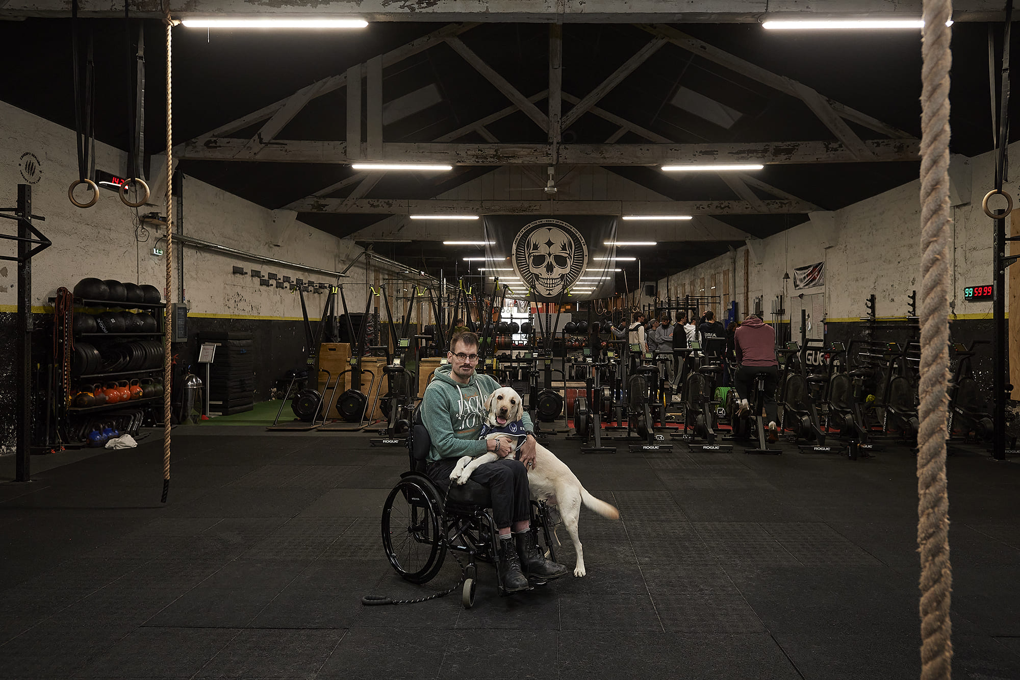 Sébastien accompagné de son chien d’assistance Saxo, photographiés par Frédéric Bourcier à la salle de CrossFit de Gerland à Lyon dans le cadre d’un reportage documentaire social pour Handi’Chiens.
