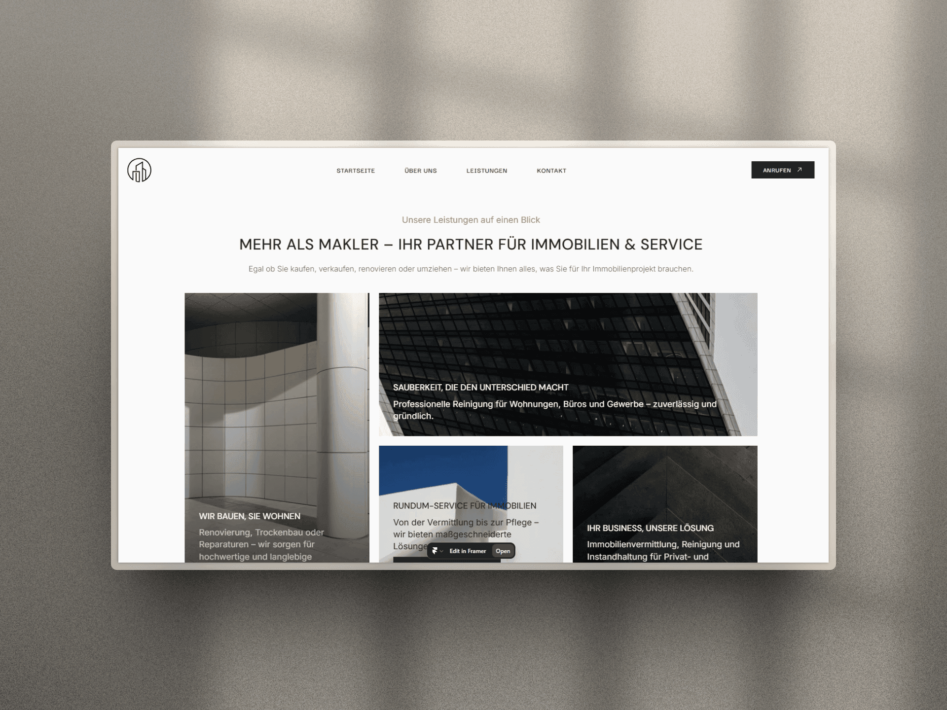 A laptop displaying a website with multiple images and a minimalist design, set against a light background.