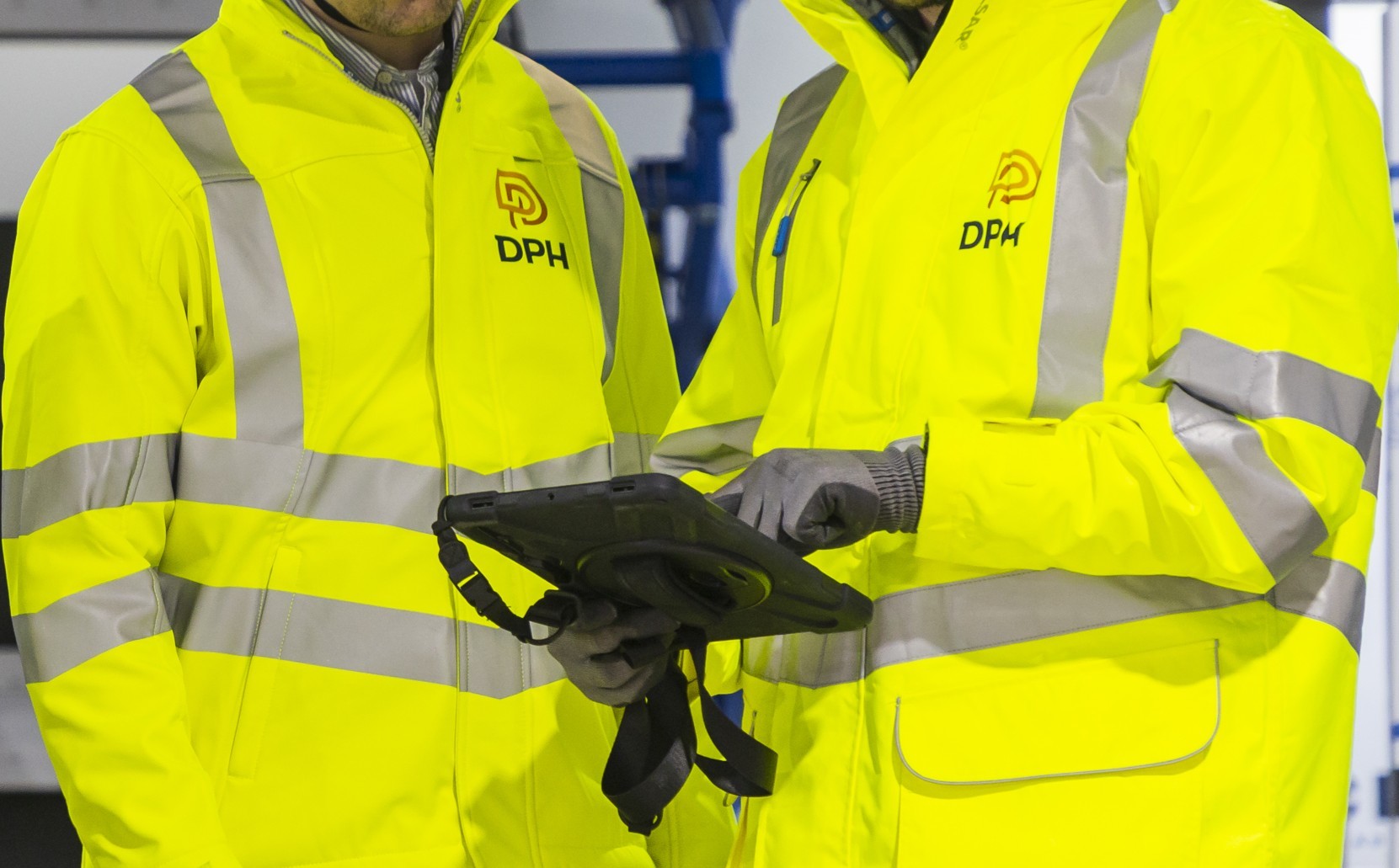Modern glass building with illuminated facade and cityscape view at sunset