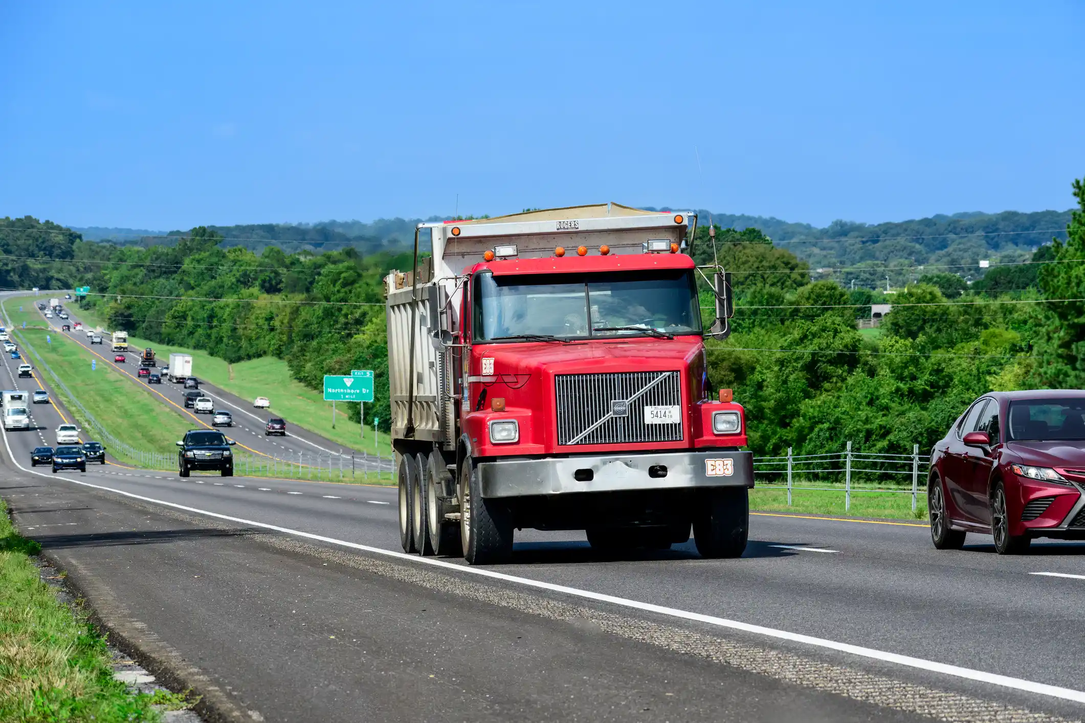 Commercial dump truck in highway traffic illustrating real-world liability exposure