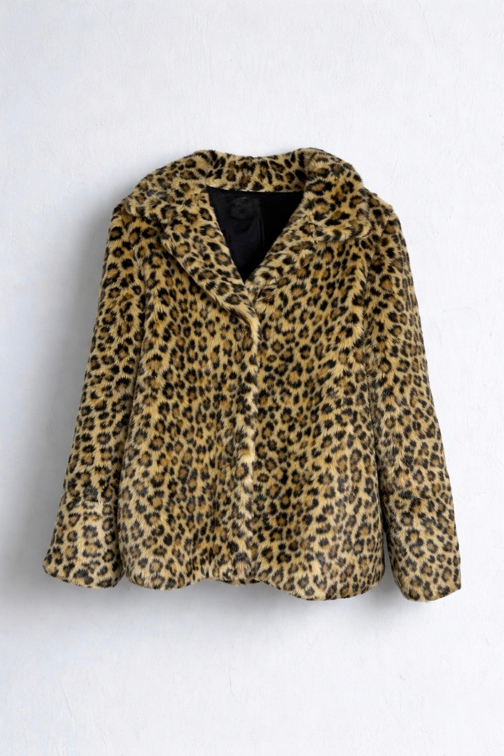 Leopard print faux fur jacket hanging on a wall