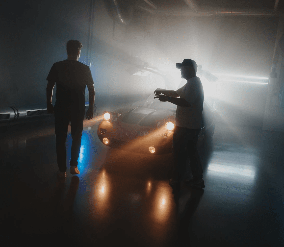Person stand in front of a red sports oldtimer