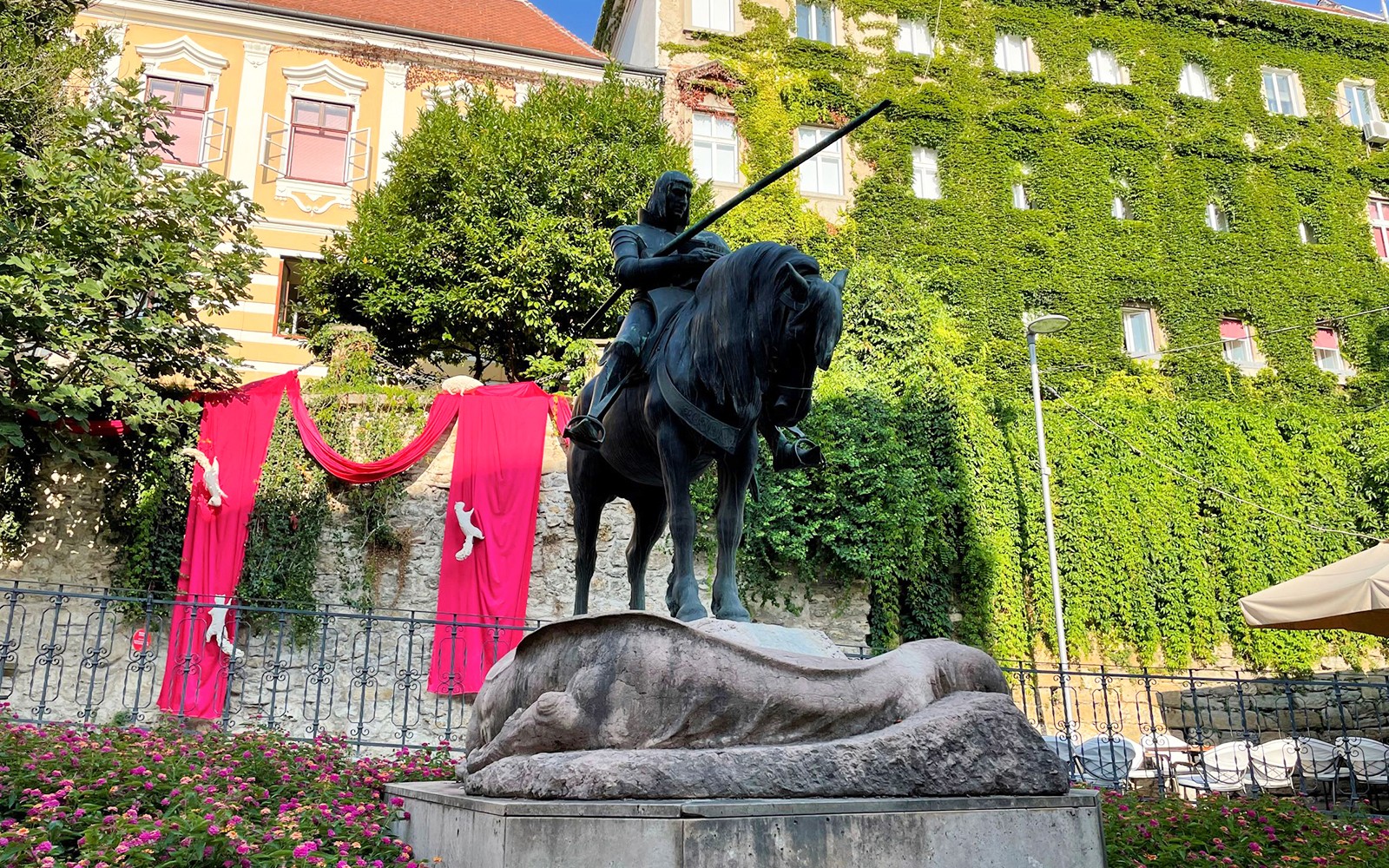 扎格雷布一位騎馬騎士的雕像，背景是一座覆滿常春藤的建築。