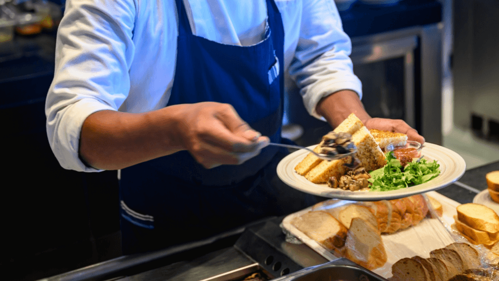 A Malaysian F&B staff serving food to a customer 