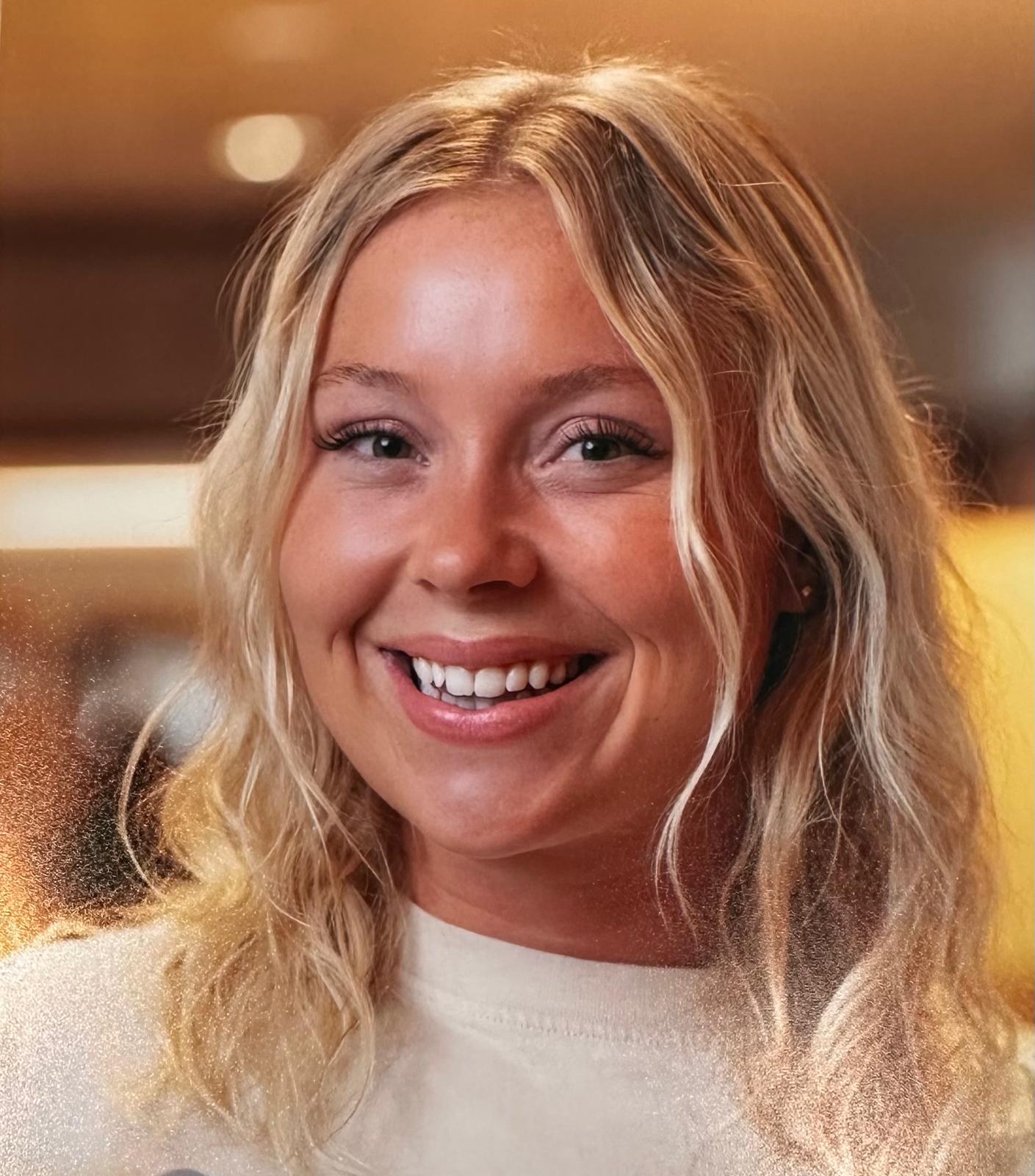 Close-up of a dark green leaf showing its textured surface and central vein against a muted background.