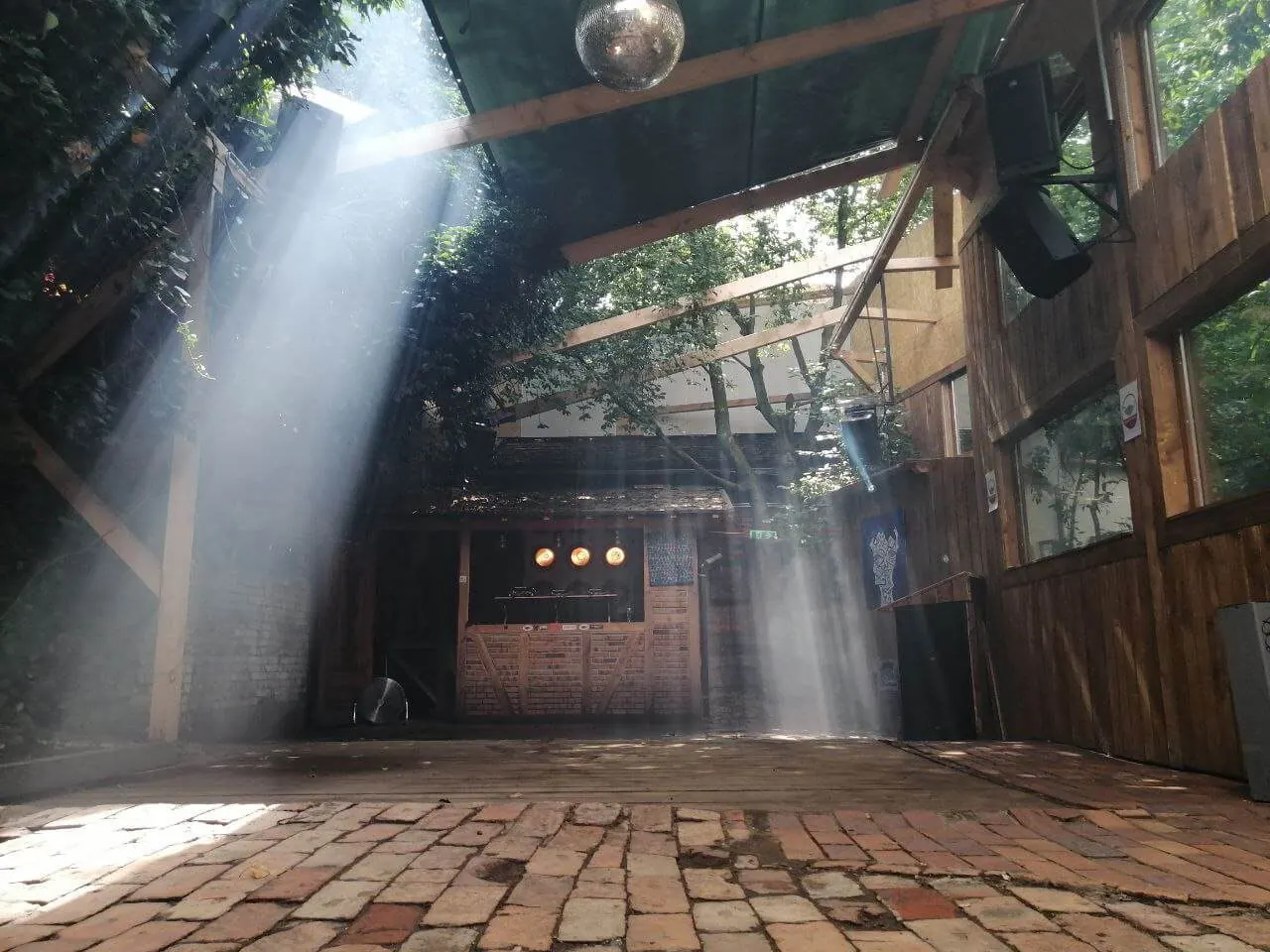 Sonnenstrahlen fallen durch das Holzdach auf den Dancefloor im ÆDEN Paradies