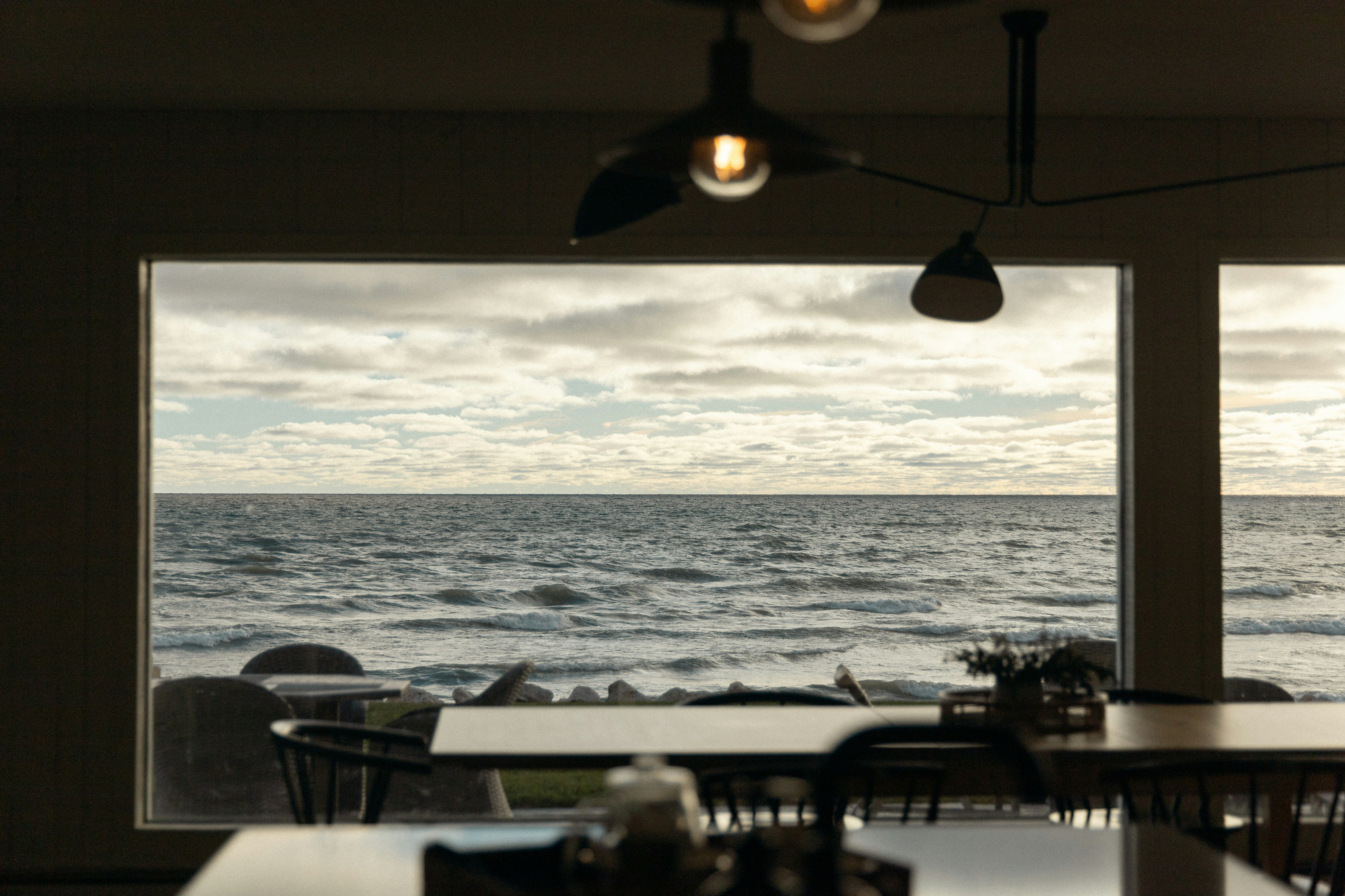 Restaurant with large windows overlooking the ocean.