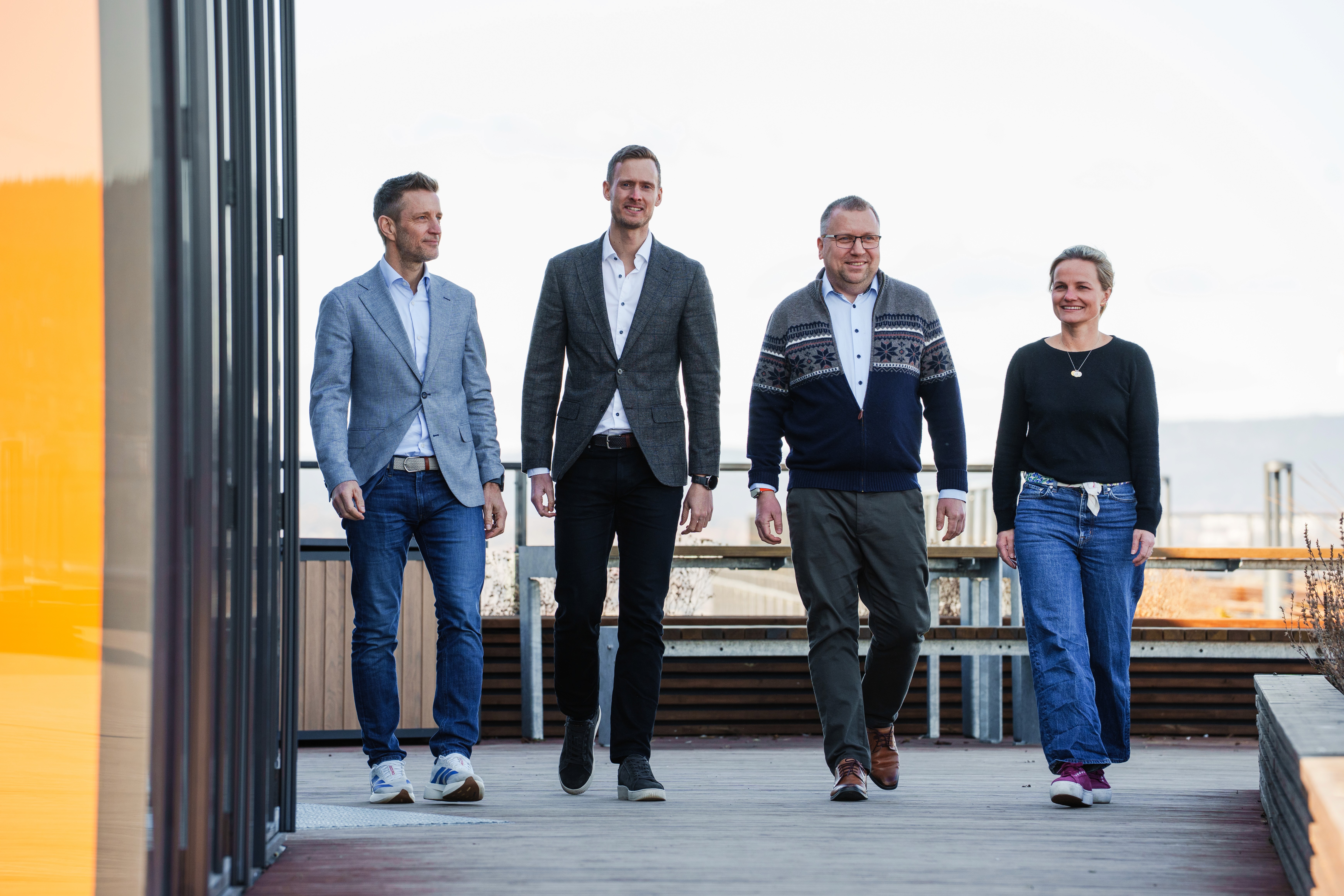 Fire personer går mot kamera på toppen av en bygning