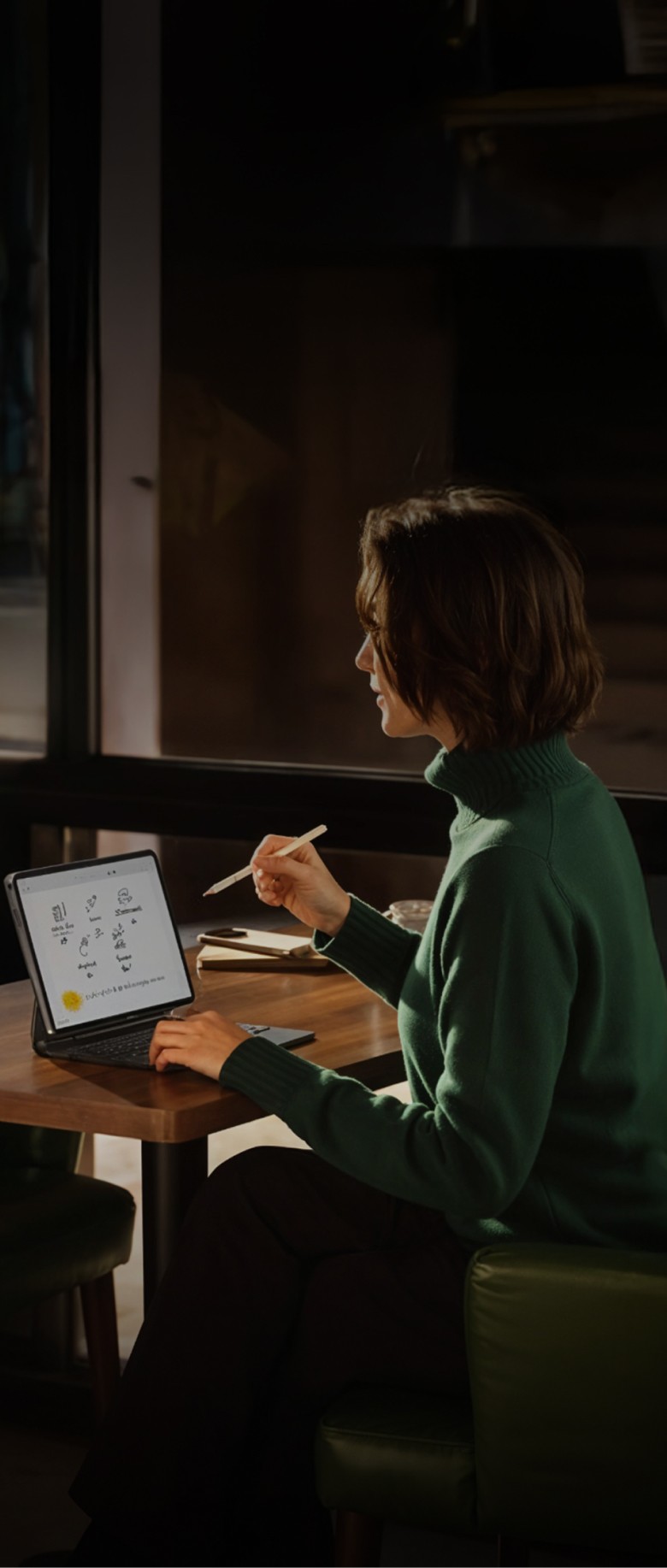 Dubai South Business Hub Free Zone -Woman working on a tablet with a stylus, sitting at a table