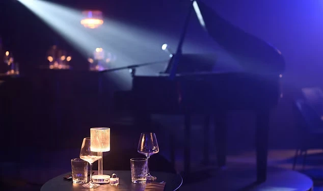 Un cocktail signature coloré posé sur une table du restaurant avec la scène en arrière-plan