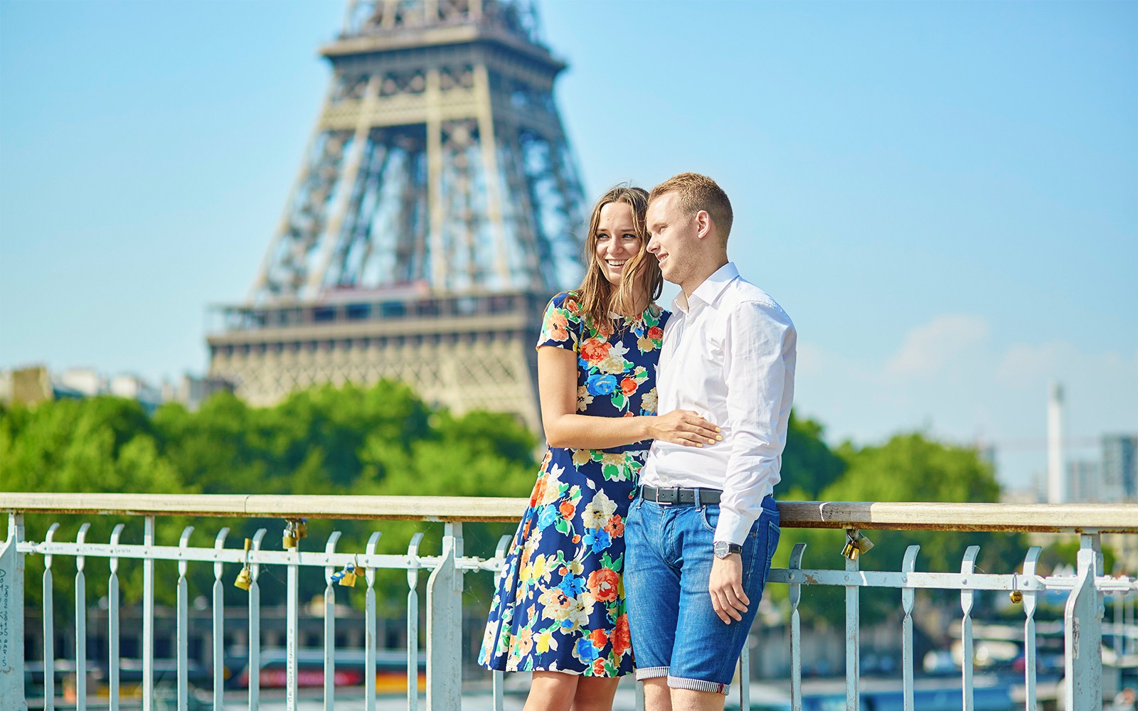 Pareja en un puente parisino con la Torre Eiffel de fondo durante un recorrido fotográfico privado.