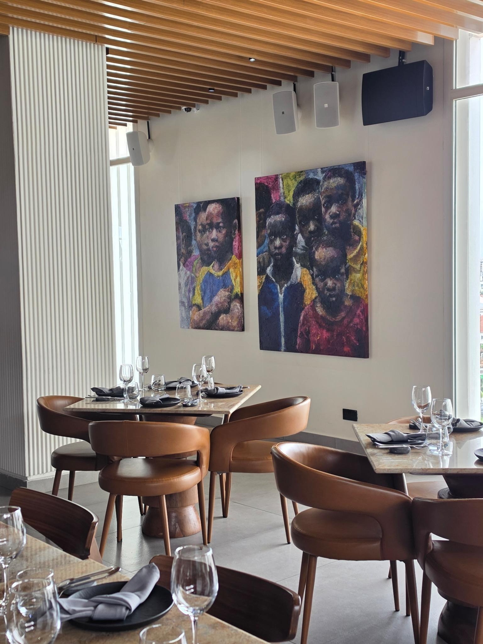 Chika Idu, The boy named Happy, 2026, mixed media, 120 × 90 cm, and The Assembly, 2026, oil on canvas, 150 × 120 cm. Installation view at ARAMI, Lagos. Photo: SMO Contemporary Art/Yinka Akingbade.