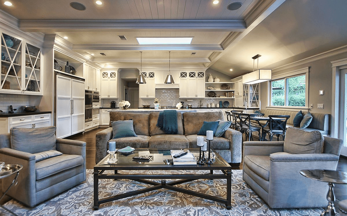 Living room with a couch in the foreground and the kitchen visible in the back.