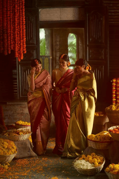 Charming vintage wedding scene of bridesmaids in traditional silk saris, surrounded by baskets of marigolds in a dimly lit room, exuding cultural heritage and old-world charm.