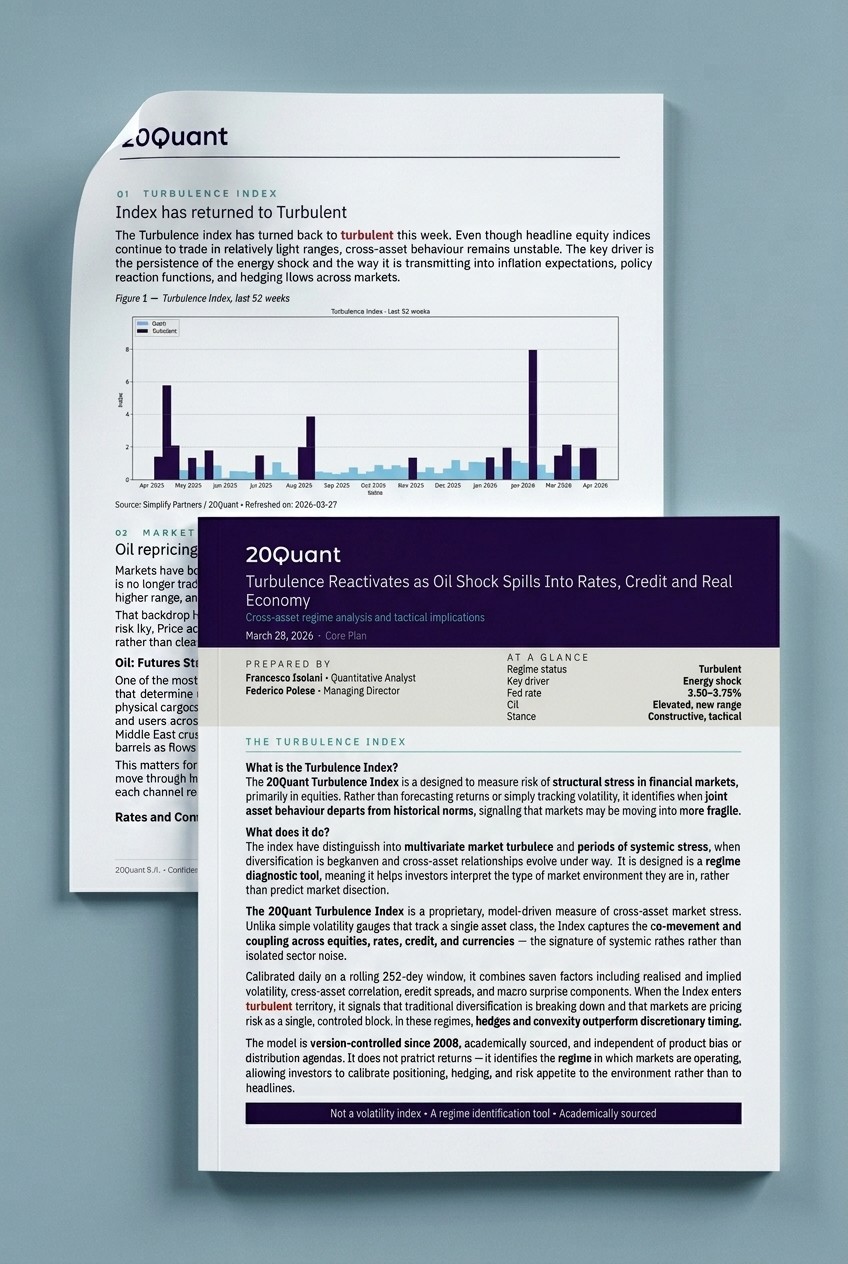 A man wearing glasses and a blazer working at a desk, writing in a notebook beside a computer monitor in a modern office.
