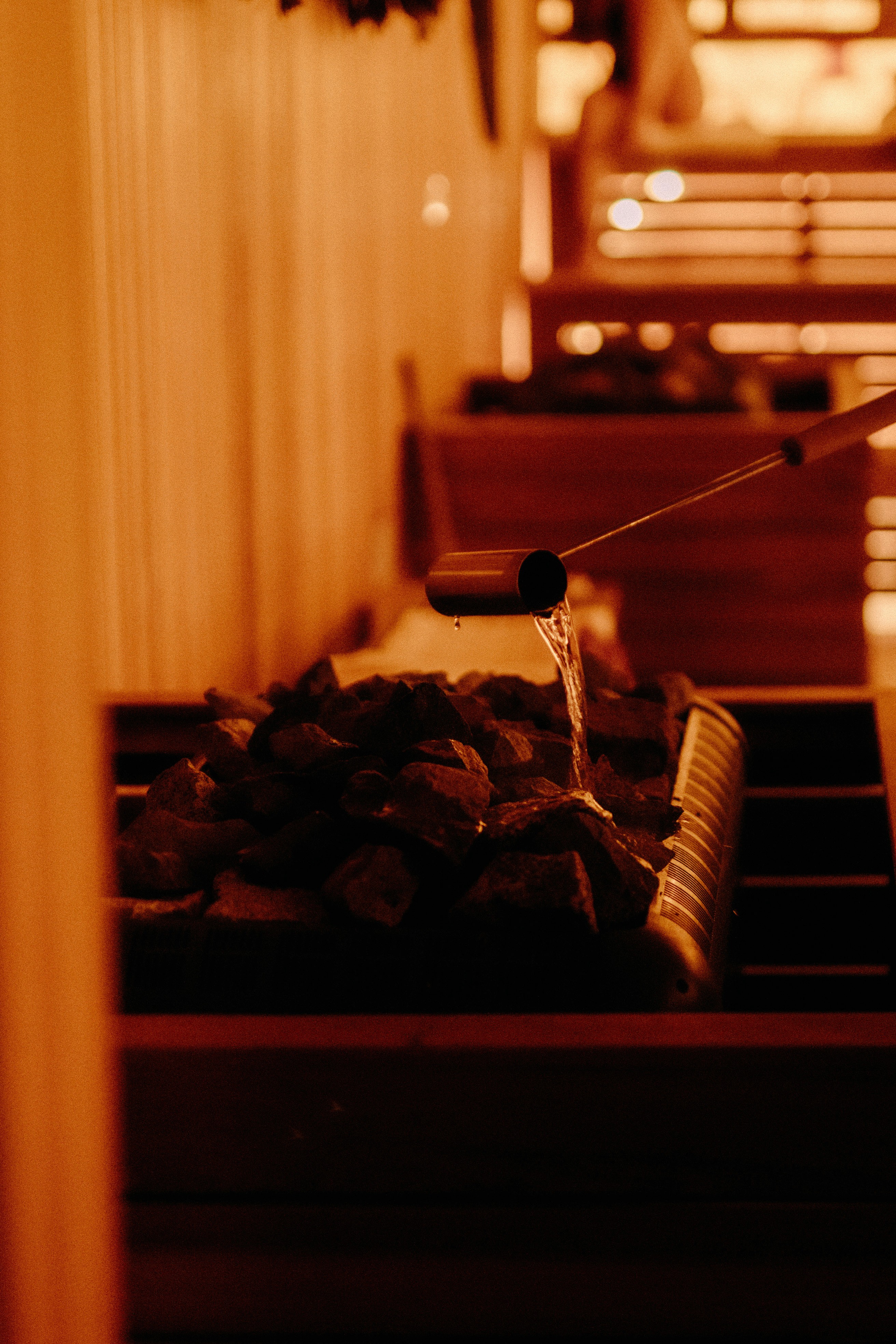 Bare feet resting on a warm cedar bench inside a softly lit sauna, capturing a moment of stillness