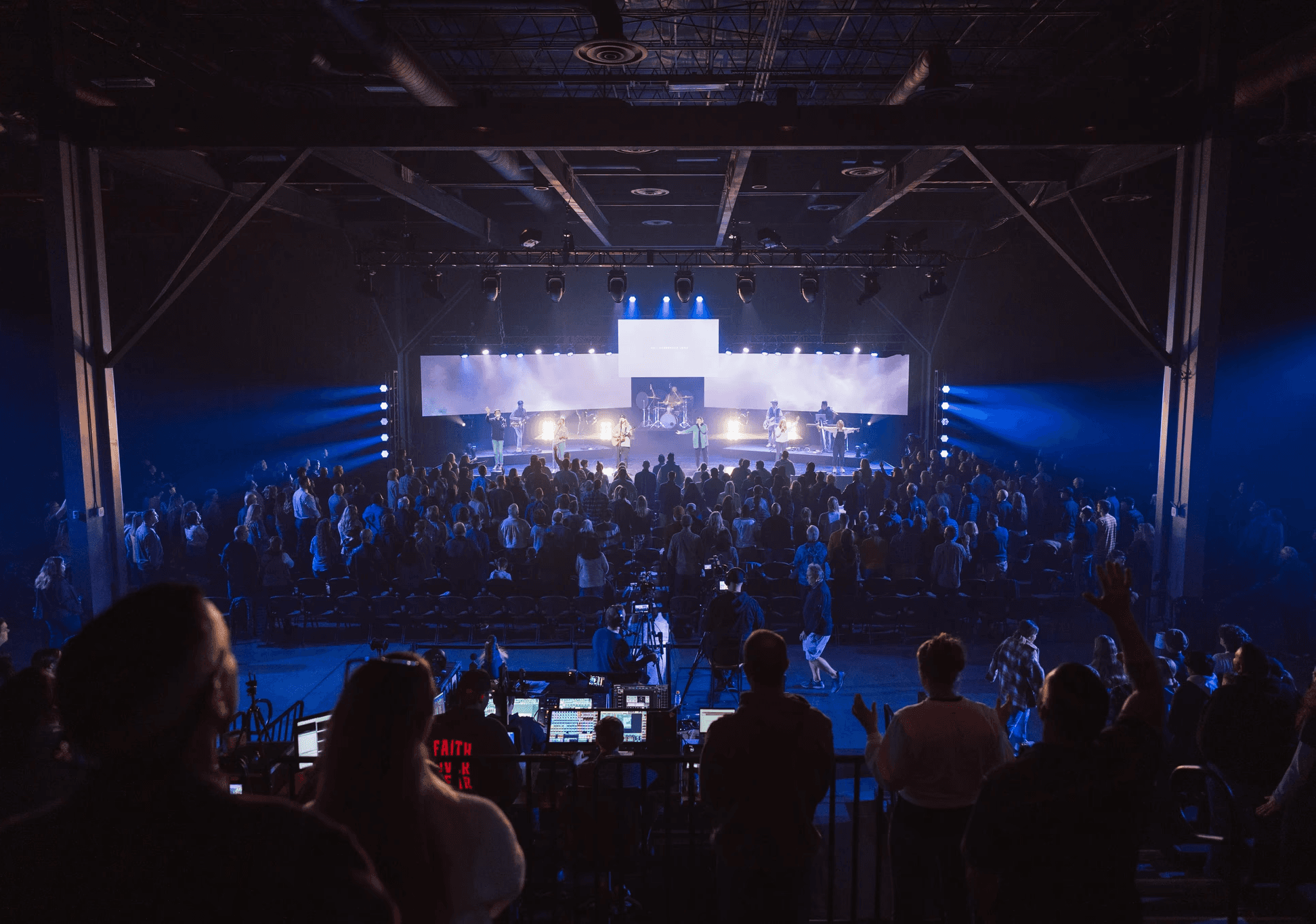 two people in a workspace working on their laptops