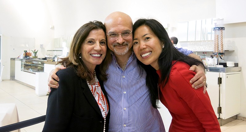 three people putting arms around each other