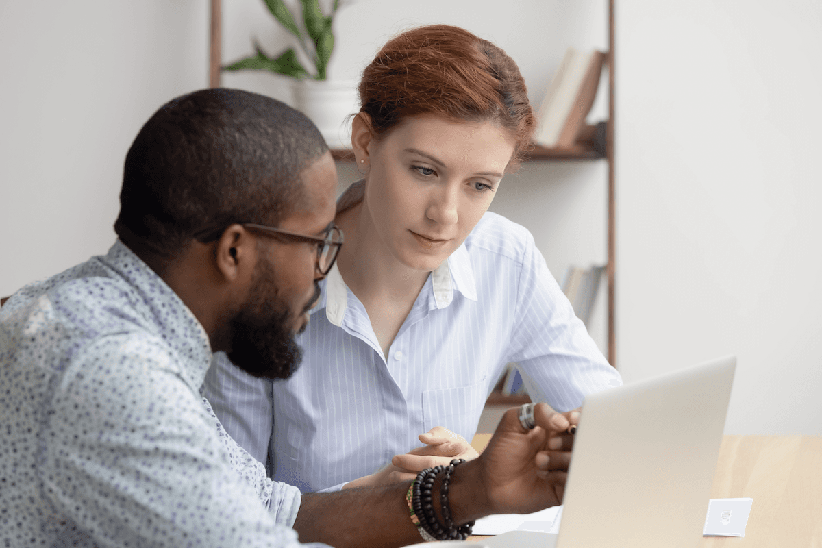 SaaS sales: two people discussing in front of a laptop