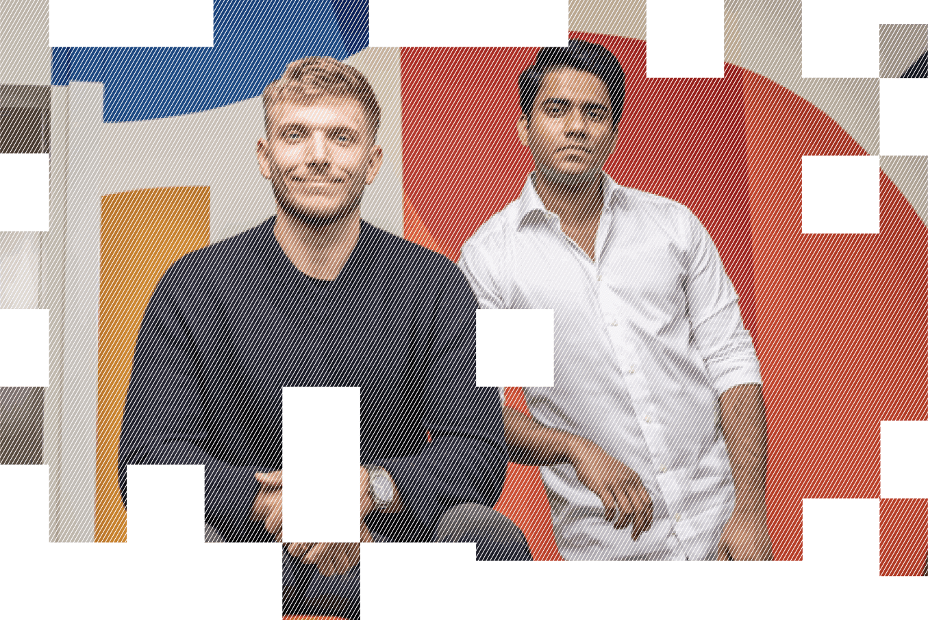 Two men stand confidently together in a brightly colored room, smiling at the camera.