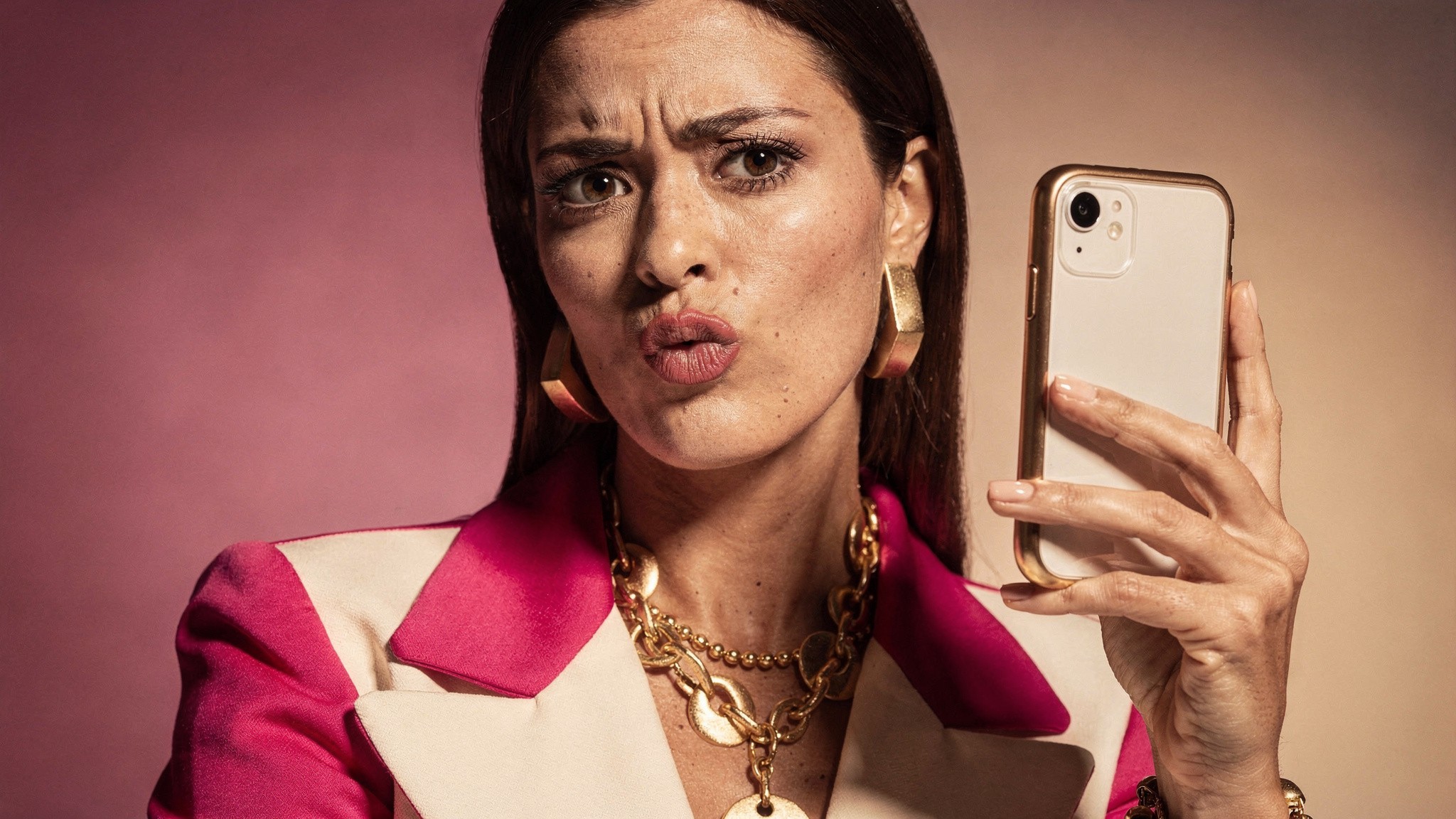 Adult woman creator with a playful frustrated expression holding her phone