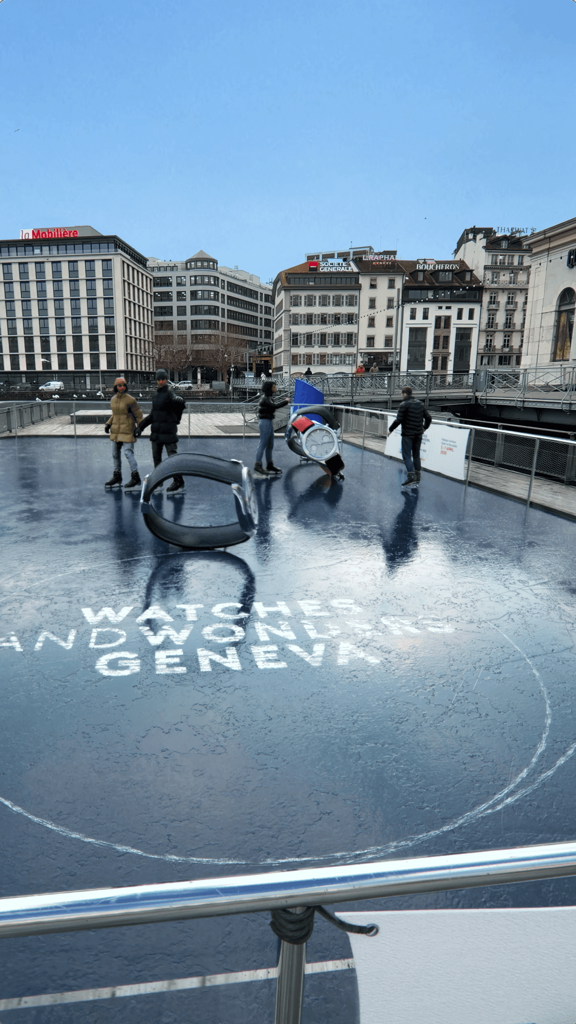 People skating on a city rink with giant luxury watches and branding on the ice