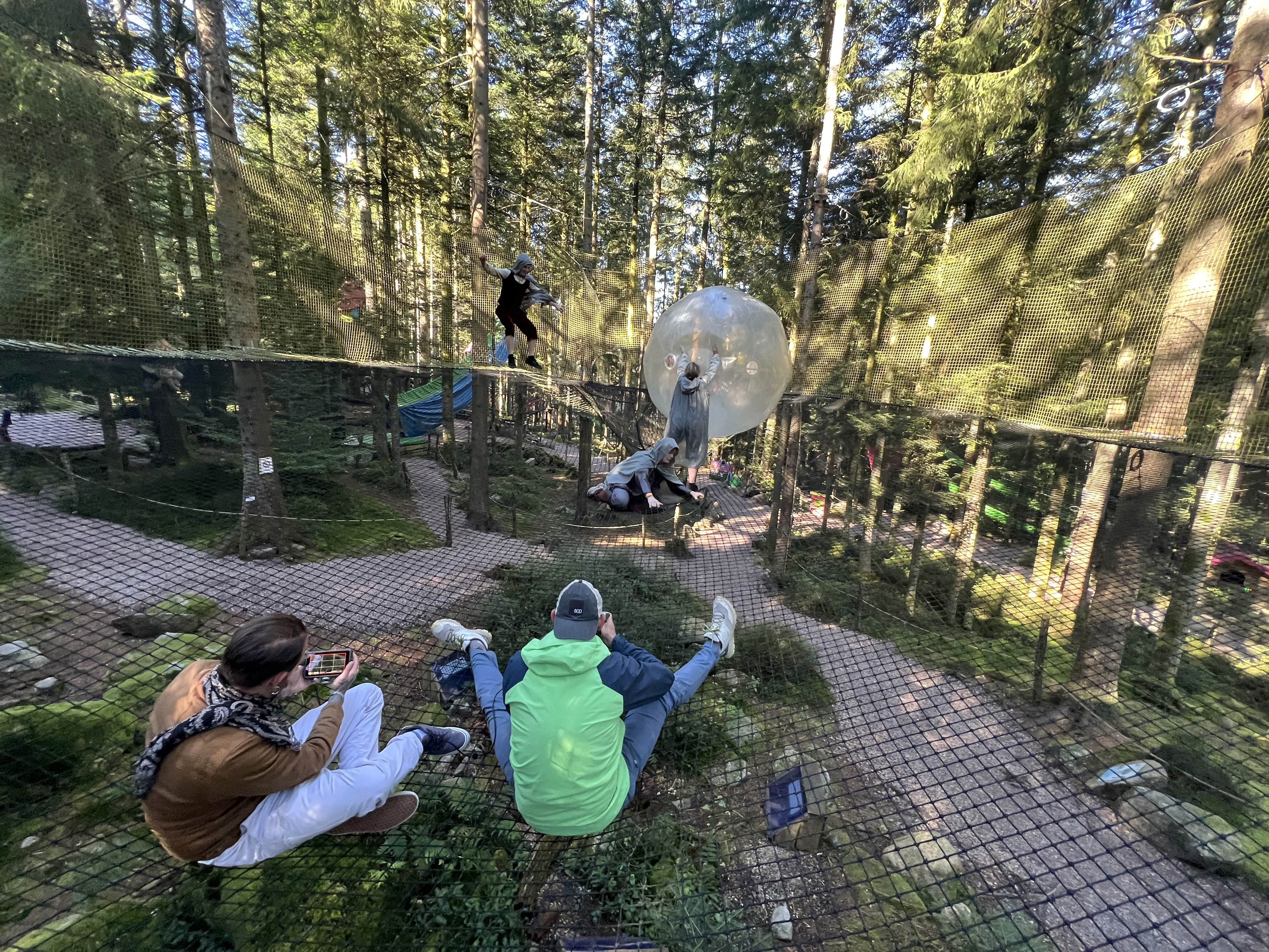 Two filmmakers operate a large camera in a dimly lit studio, wearing headphones and focused intently on the screen, conveying concentration.