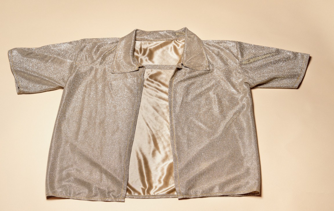 Flat lay of a handmade short-sleeve shirt in neutral tones with visible lining.