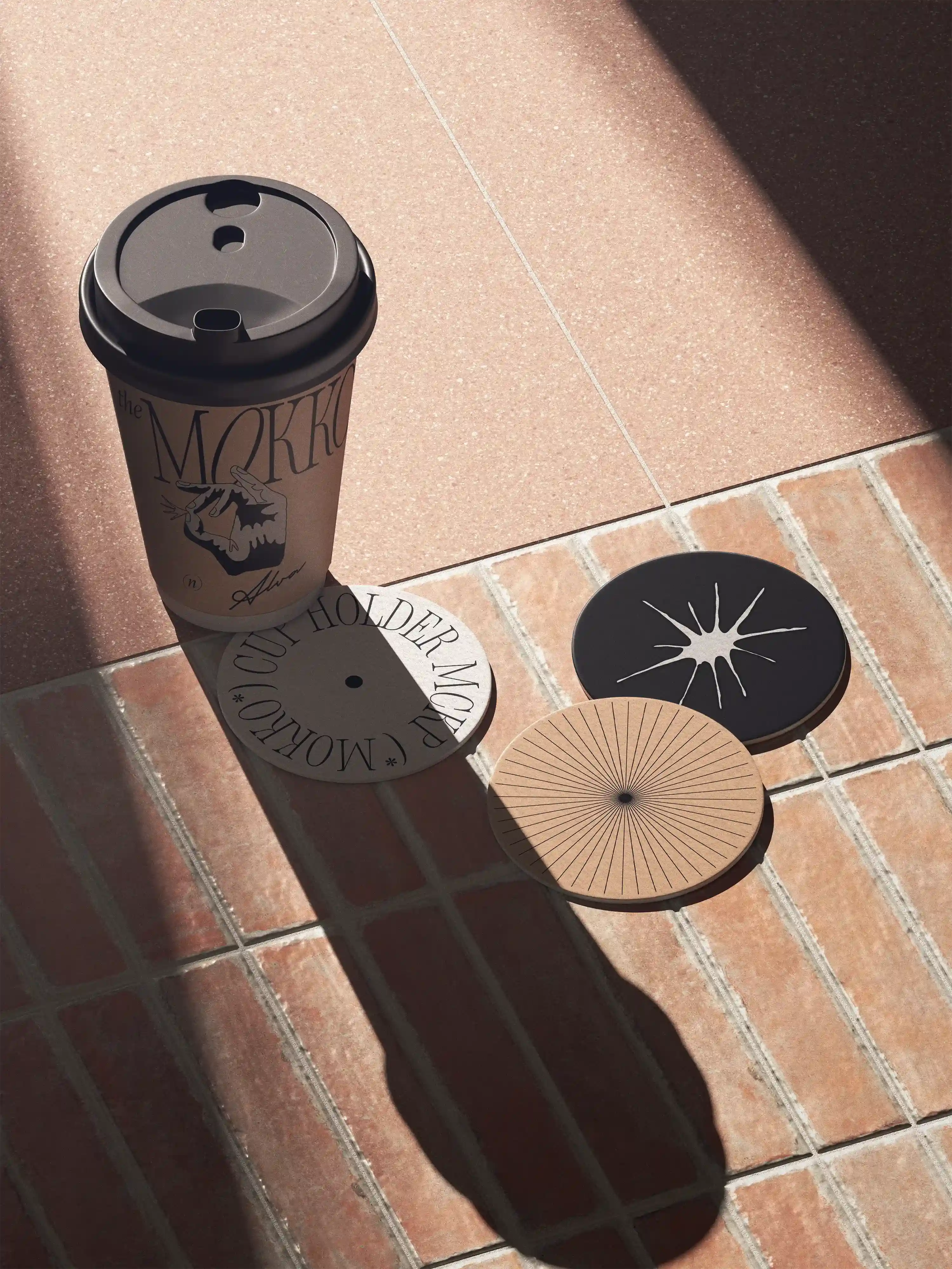 Branded to-go cup with circular coasters on terracotta tile floor
