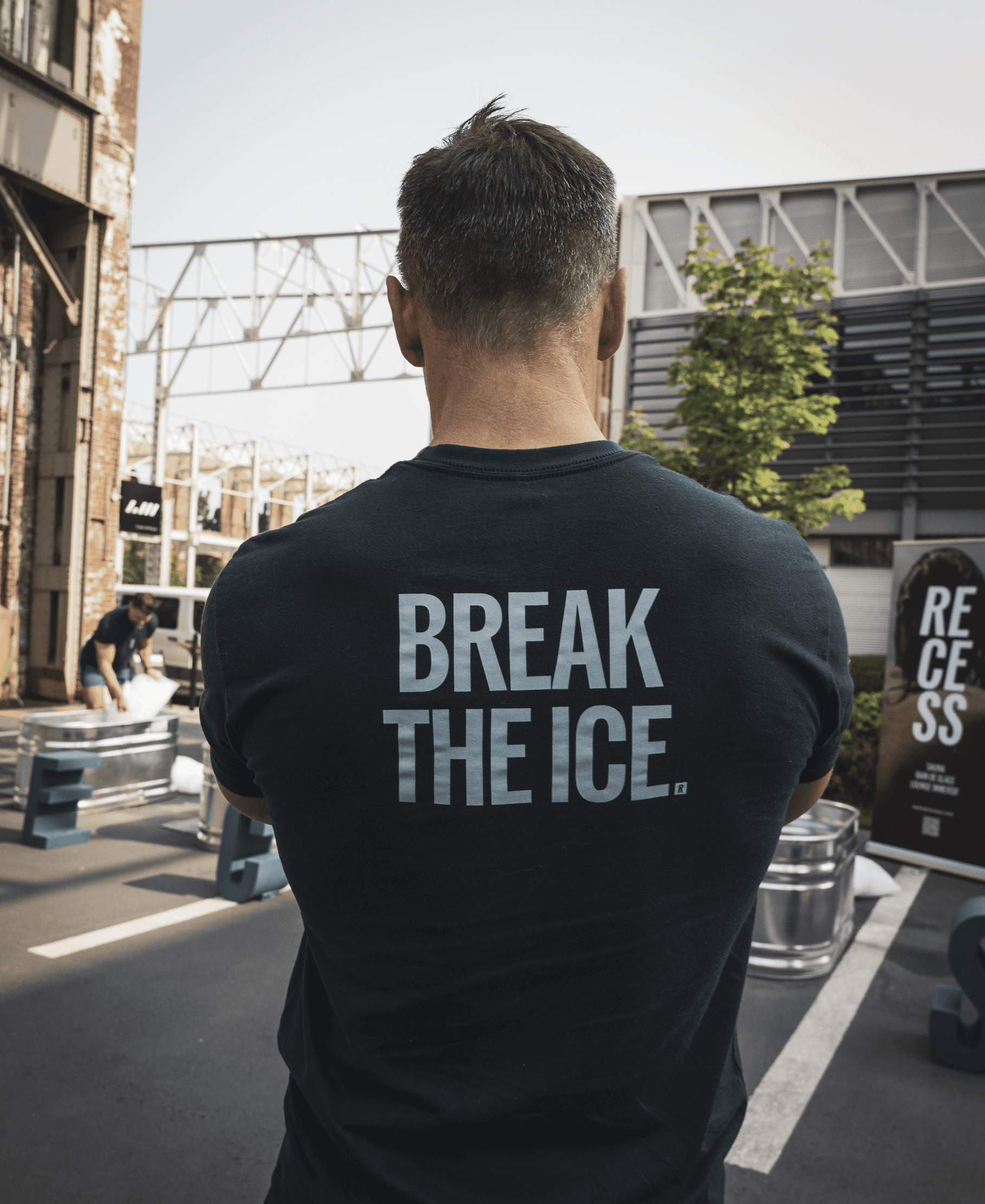 A person holds a black thermometer submerged in a body of water filled with floating ice cubes, capturing a temperature reading amidst the cold environment.