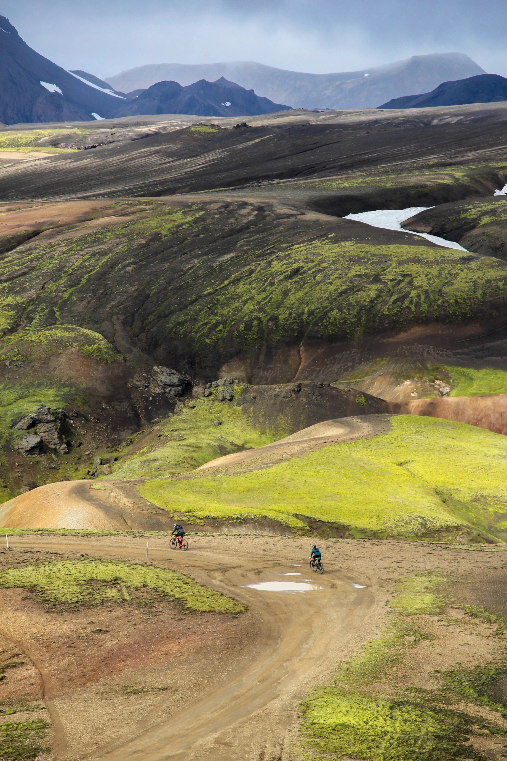 Two people riding down a mountain on a bike