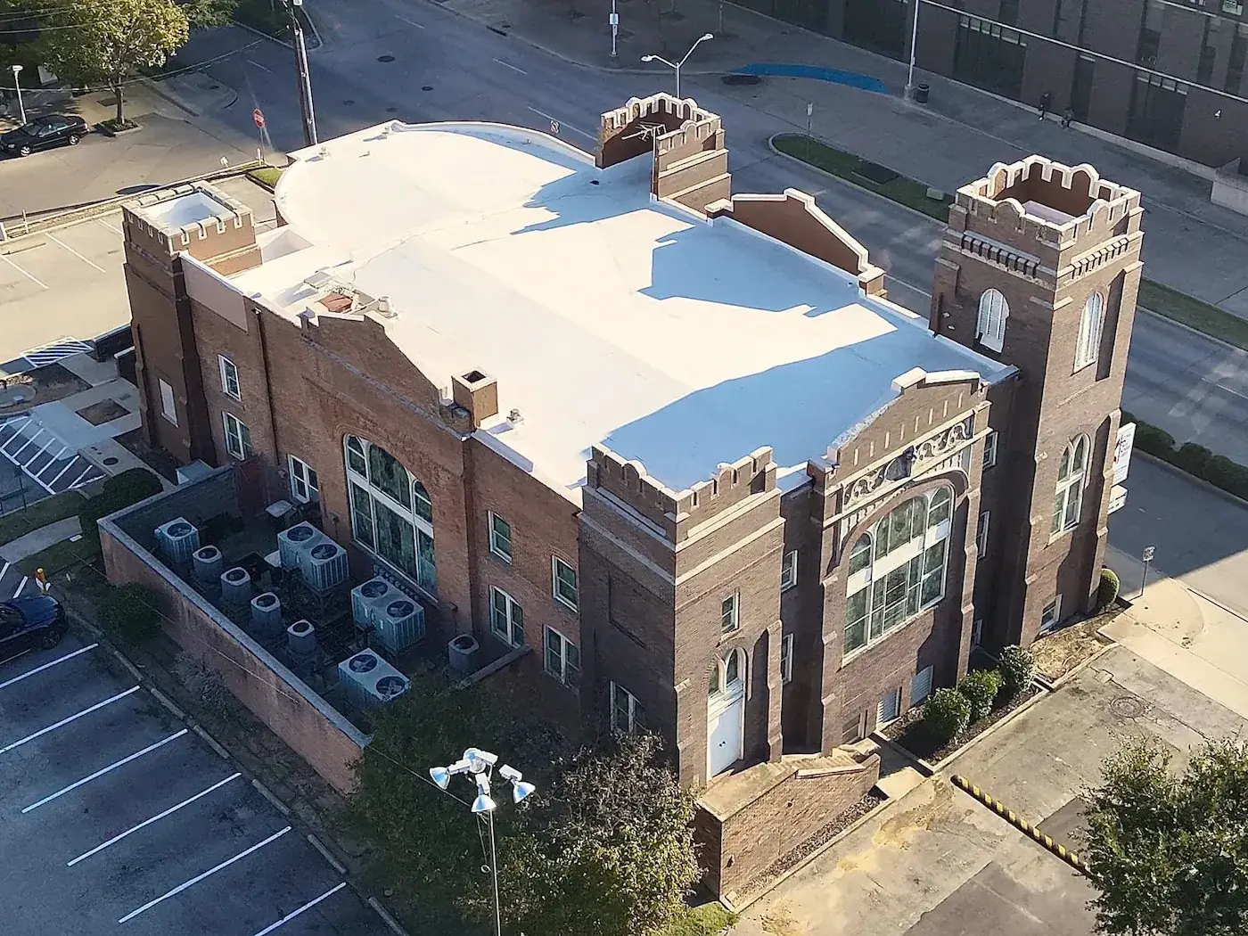 Aerial view of commercial flat roof replacement on historic brick building in Dallas by Arrington Roofing