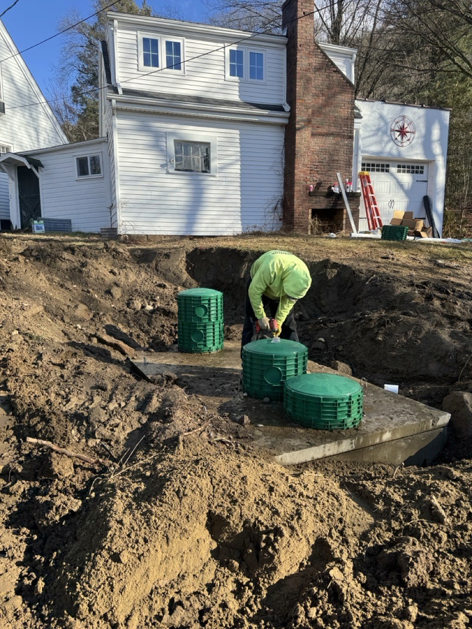 Crew setting green risers on a new septic tank, by A&M Construction Enterprises