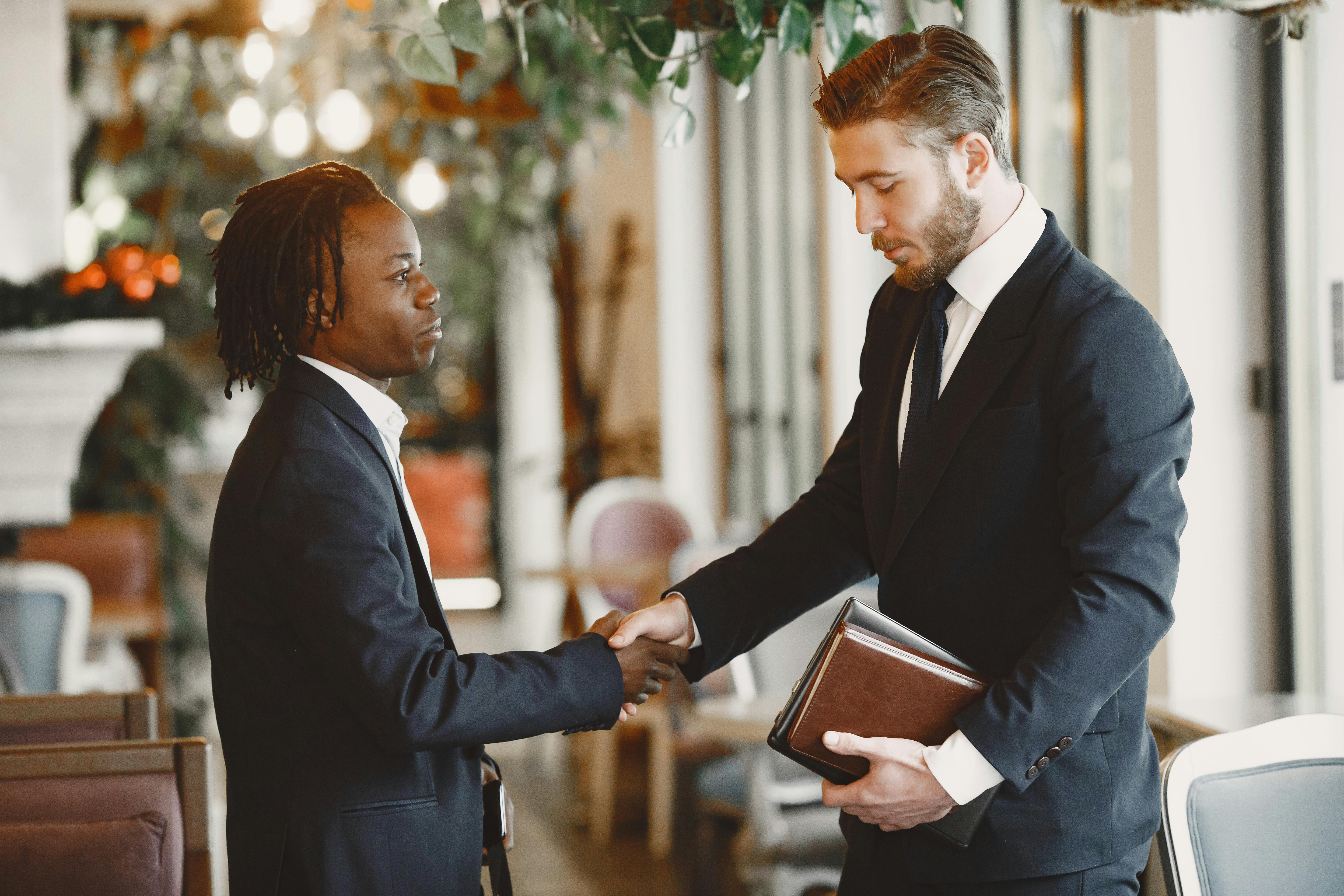 green grass field with trees and mountains in the distance